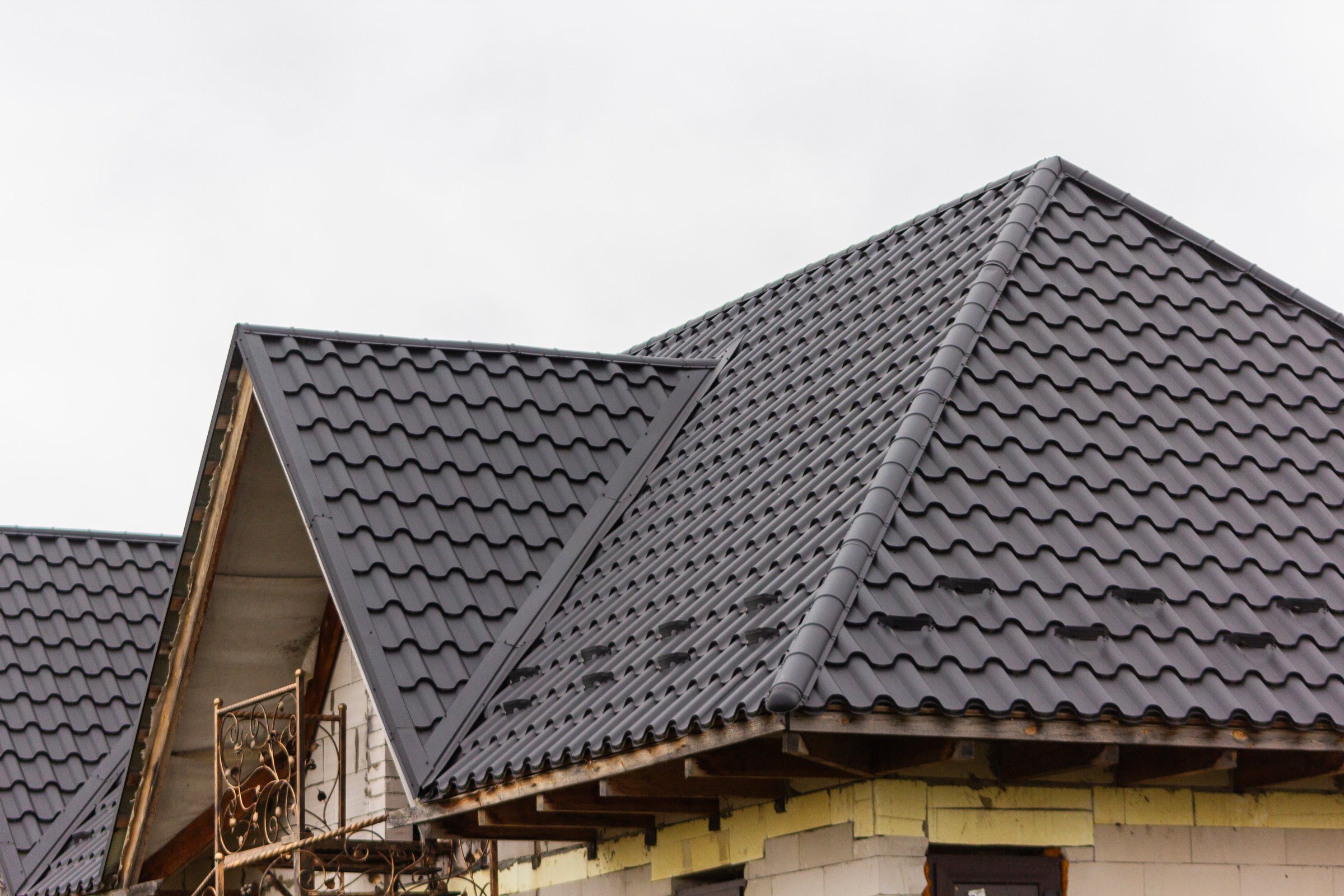 Covering the house with metal tiles. Close-up of the slope of the roof.