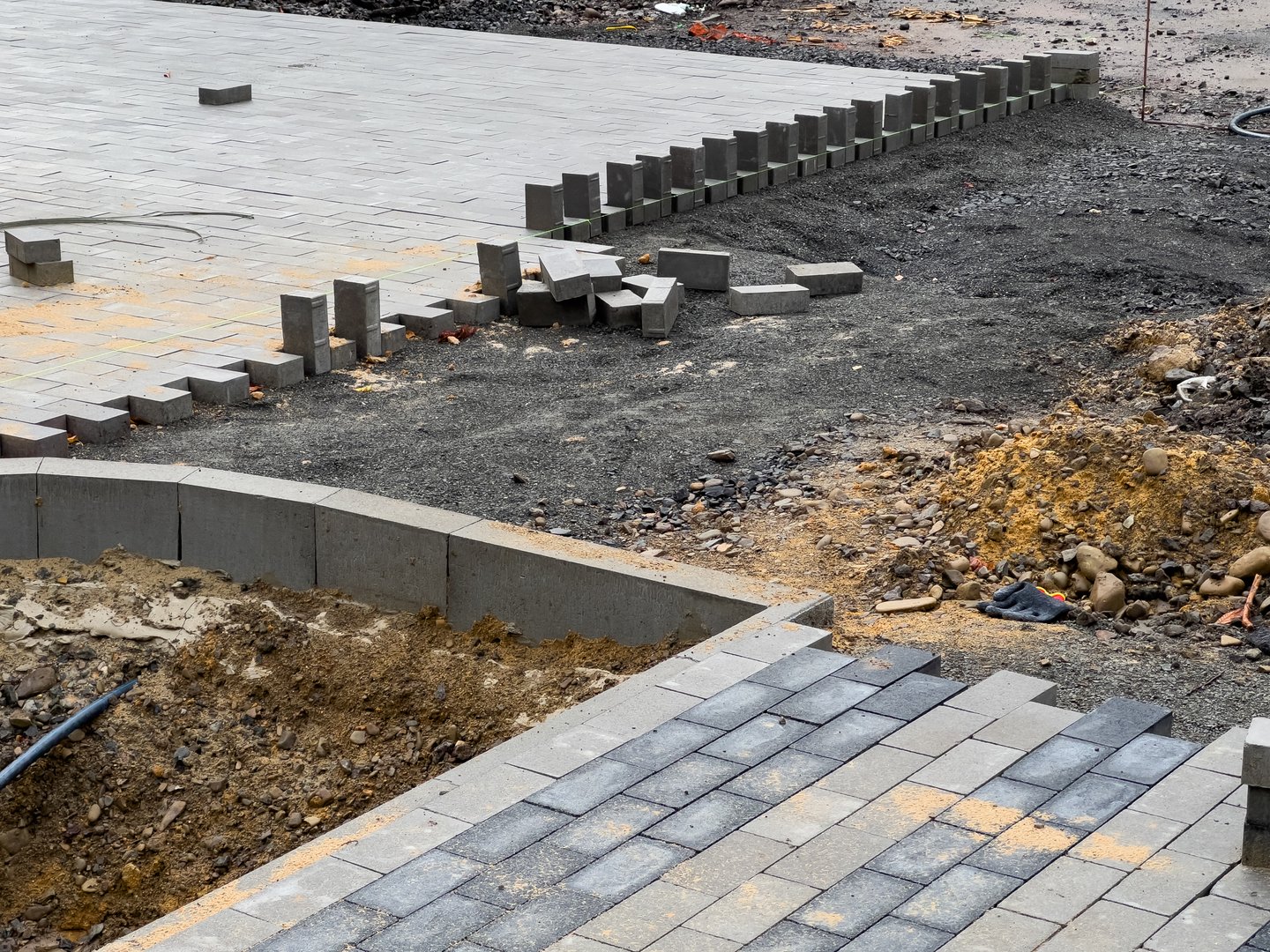 Construction workers are laying paving stones on a new driveway