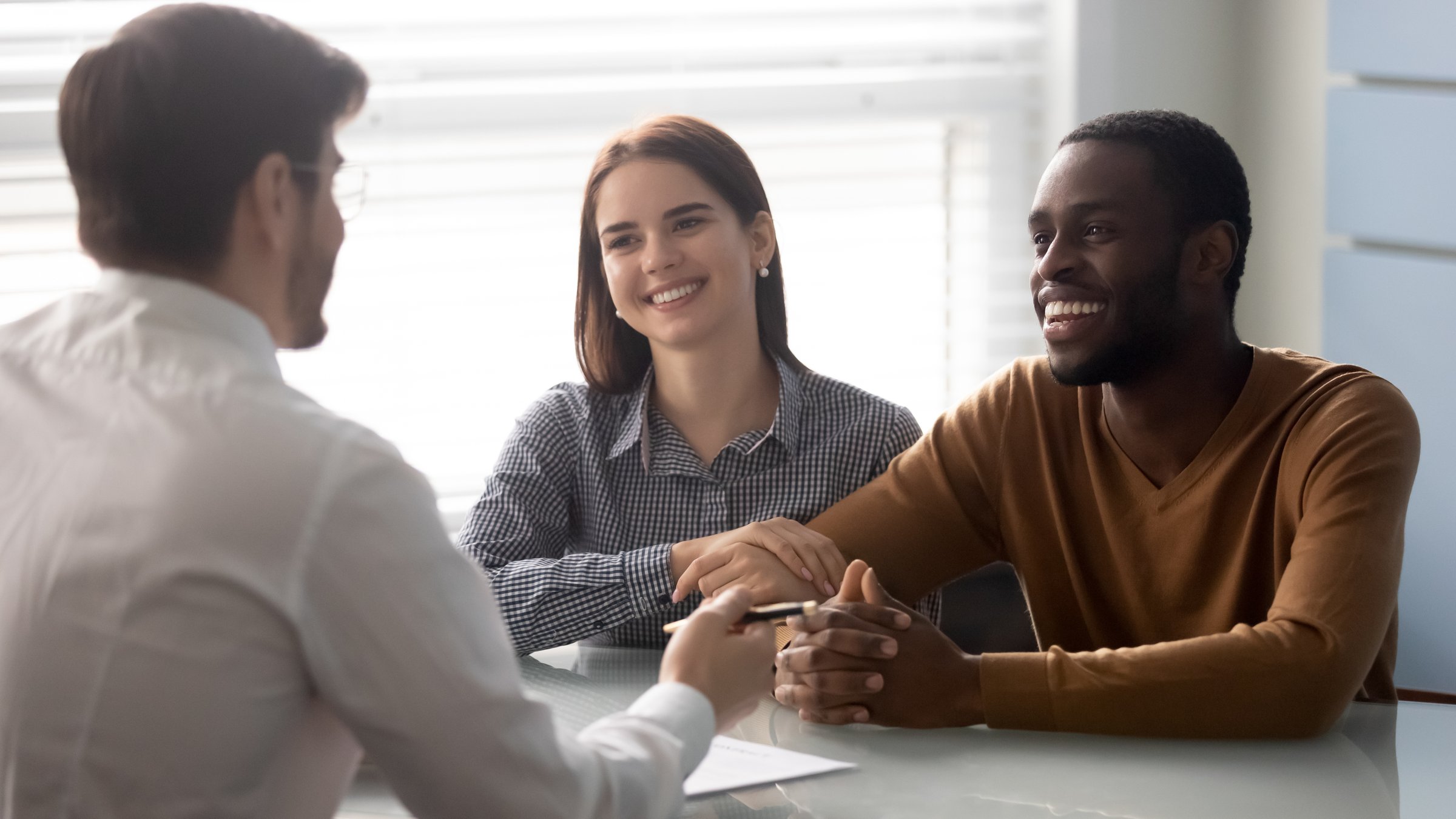 Interracial couple at meeting with financial advisor in office, receive consultation about deposit, savings, getting lease mortgage opportunity, estate agent and clients discuss profitable conditions of tenancy contract