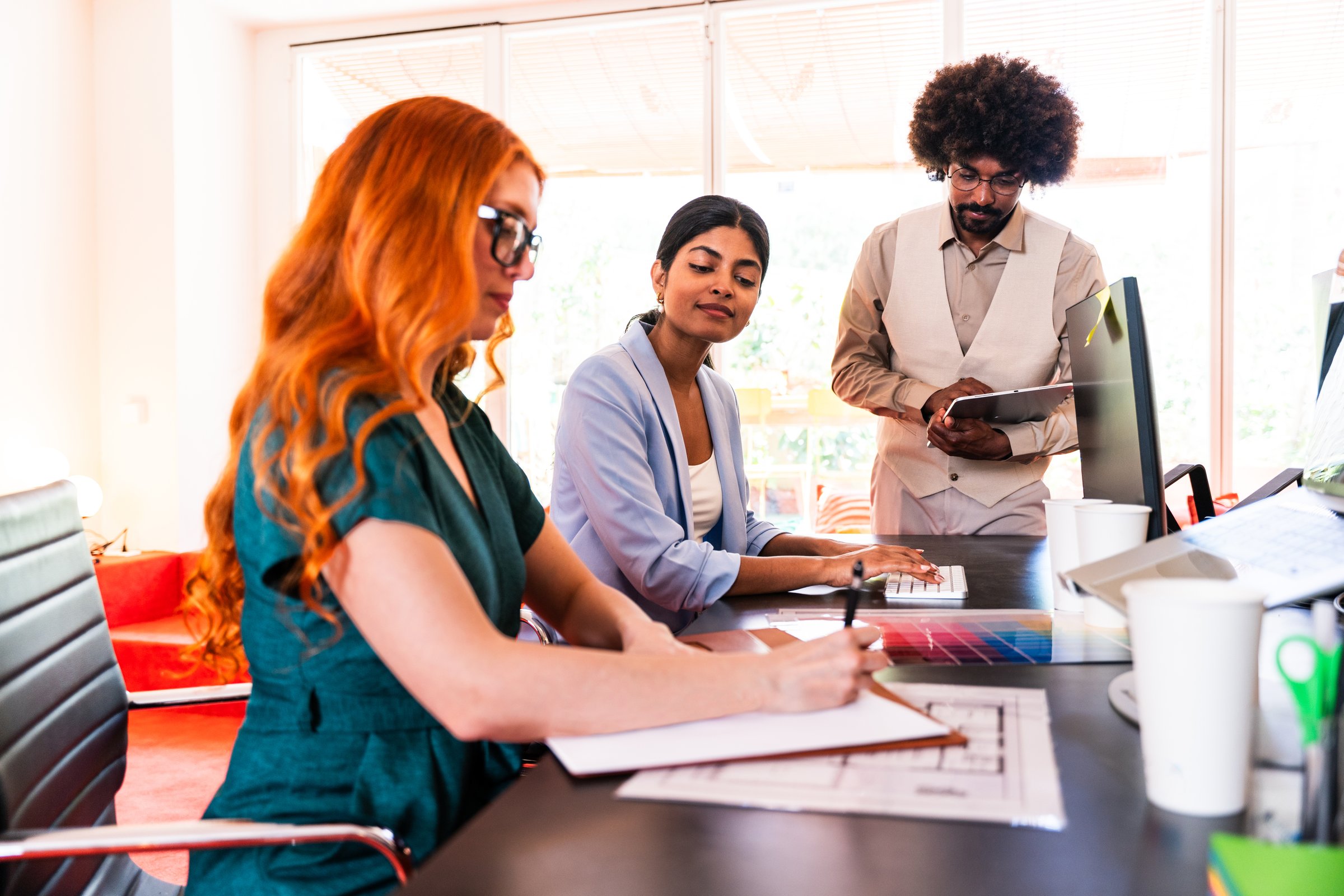 Multiethnic small group of businesspeople meeting in a coworking corporate company office - Young coworkers colleagues working together in a creative startup tech company, concepts about business and daily office lifestyle