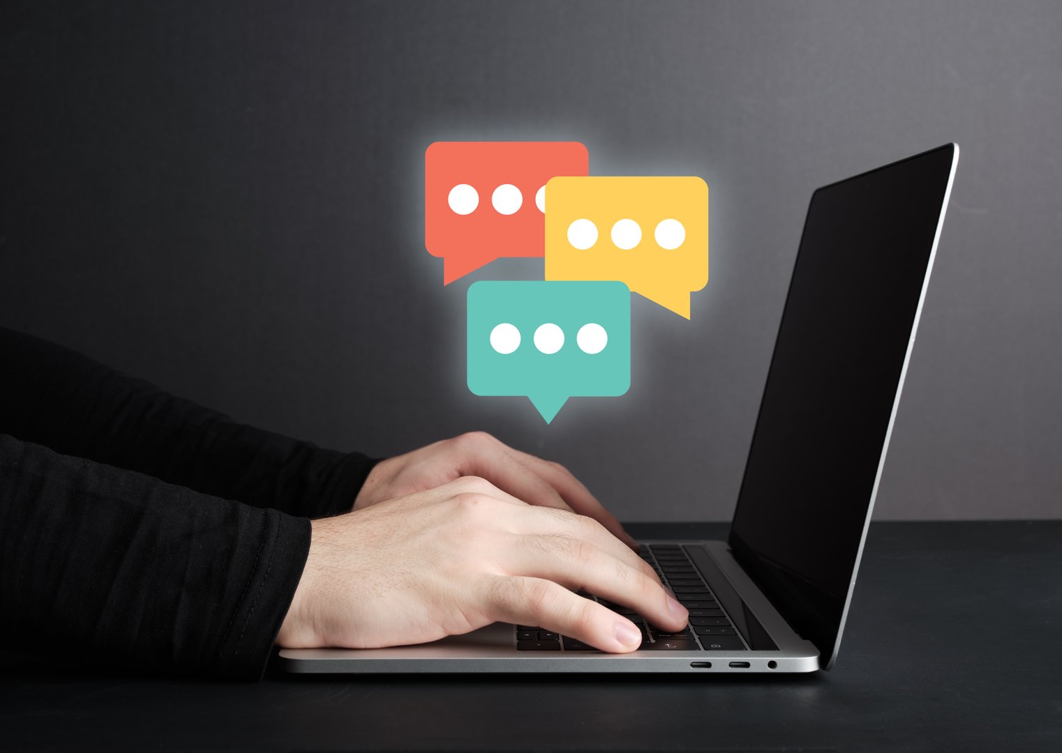 Male hands messaging or chatting on laptop computer, online communication concept.