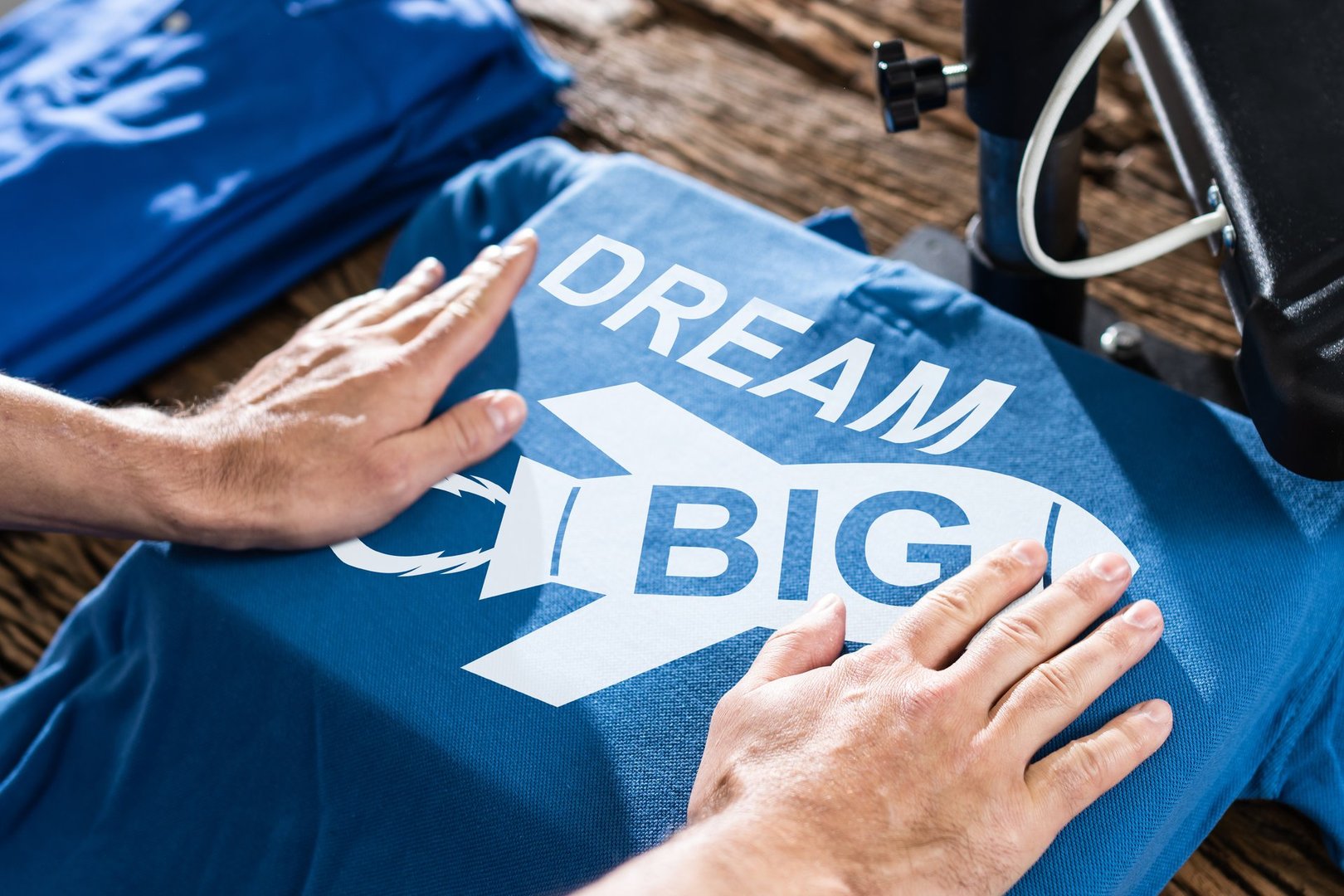 Man Printing On T Shirt In Workshop