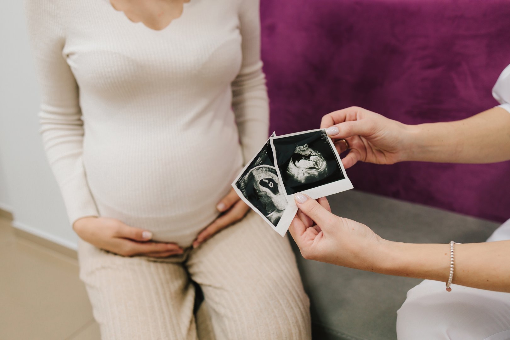 Gynecologist shows a sonographic picture of the baby to pregnant woman. Consulting pregnant patient about embryo health