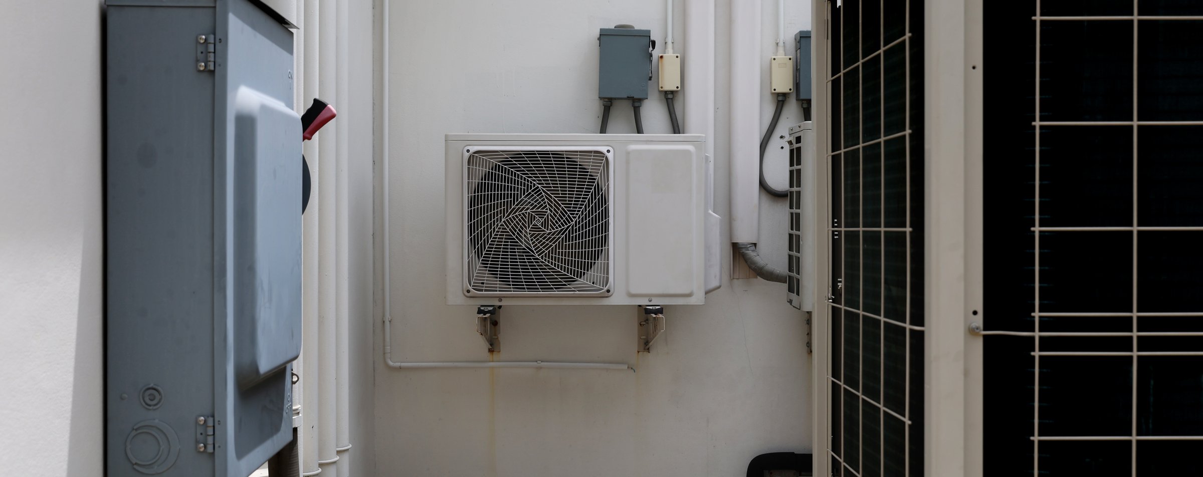 Air conditioner compressor installed in old building. Outdoor split wall type air conditioner compressor unit inverter installed on the outside of the building. Air conditioner compressor outdoor unit