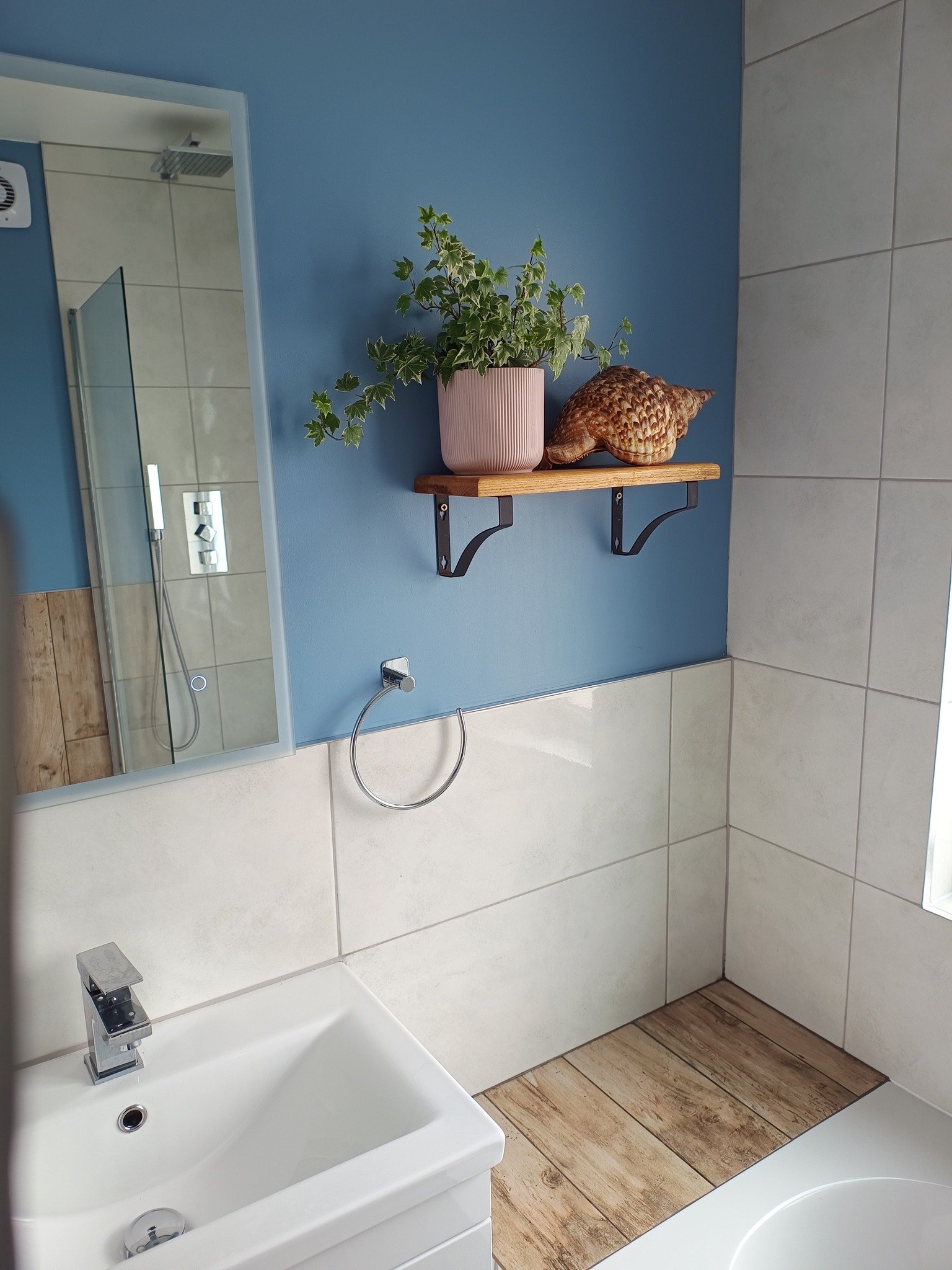 Newly built home bathroom interior primary or master bath with glass wall shower white marble granite floors and countertops large windows with blinds covering free standing bathtub sinks black fixtures bright spacious modern