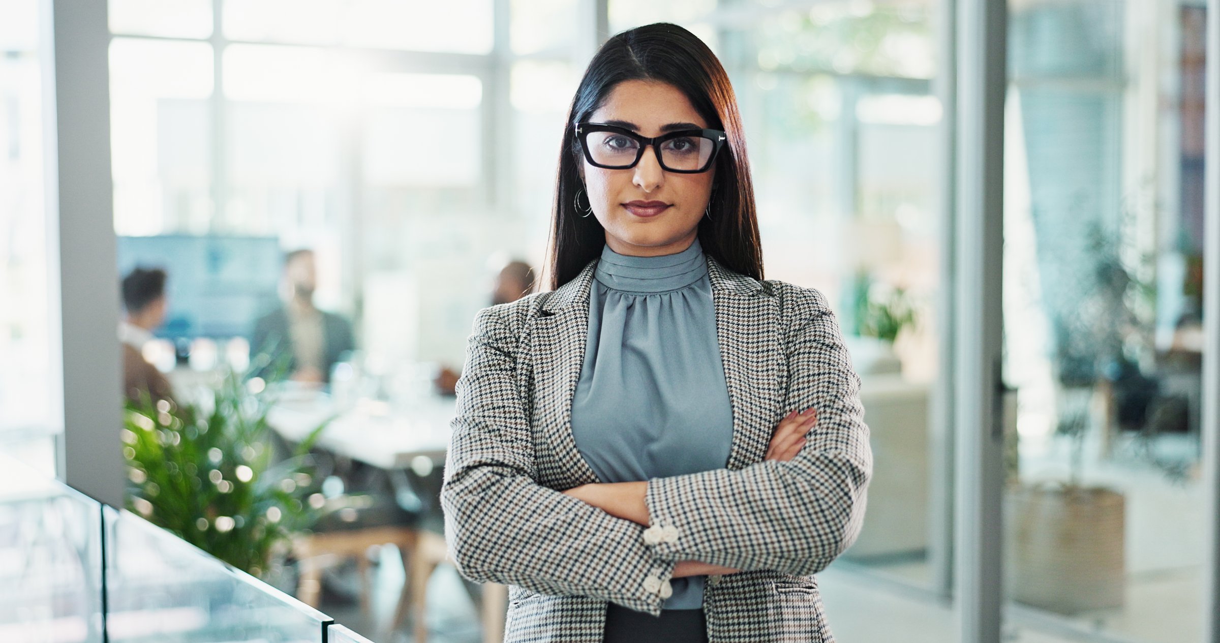 Arms crossed, portrait and smile of business Indian woman in office for corporate career development. Confident, glasses and pride with serious employee person in workplace for professional job