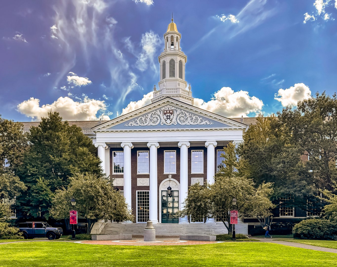 Boston MA USA Sep 3 2025:  The Baker Library-Bloomberg Center at Harvard Business School (HBS.) HBS  is one of the most iconic academic buildings at Harvard and serves as the intellectual and architectural centerpiece of the HBS campus. It's both a historic landmark and a modern research hub, combining classical design with cutting-edge resources for business scholarship. 

Opened in 1927, it is one of the largest business libraries in the world. 

Its design is Georgian Revival, characterized by its symmetry, red-brick façade, white columns, and distinctive cupola. The architects, McKim, Mead & White, were the most distinguished architectural firm in New York City. 

Modeled after Independence Hall in Philadelphia, the 70-foot-high cupola is one of HBS's most recognizable symbols.