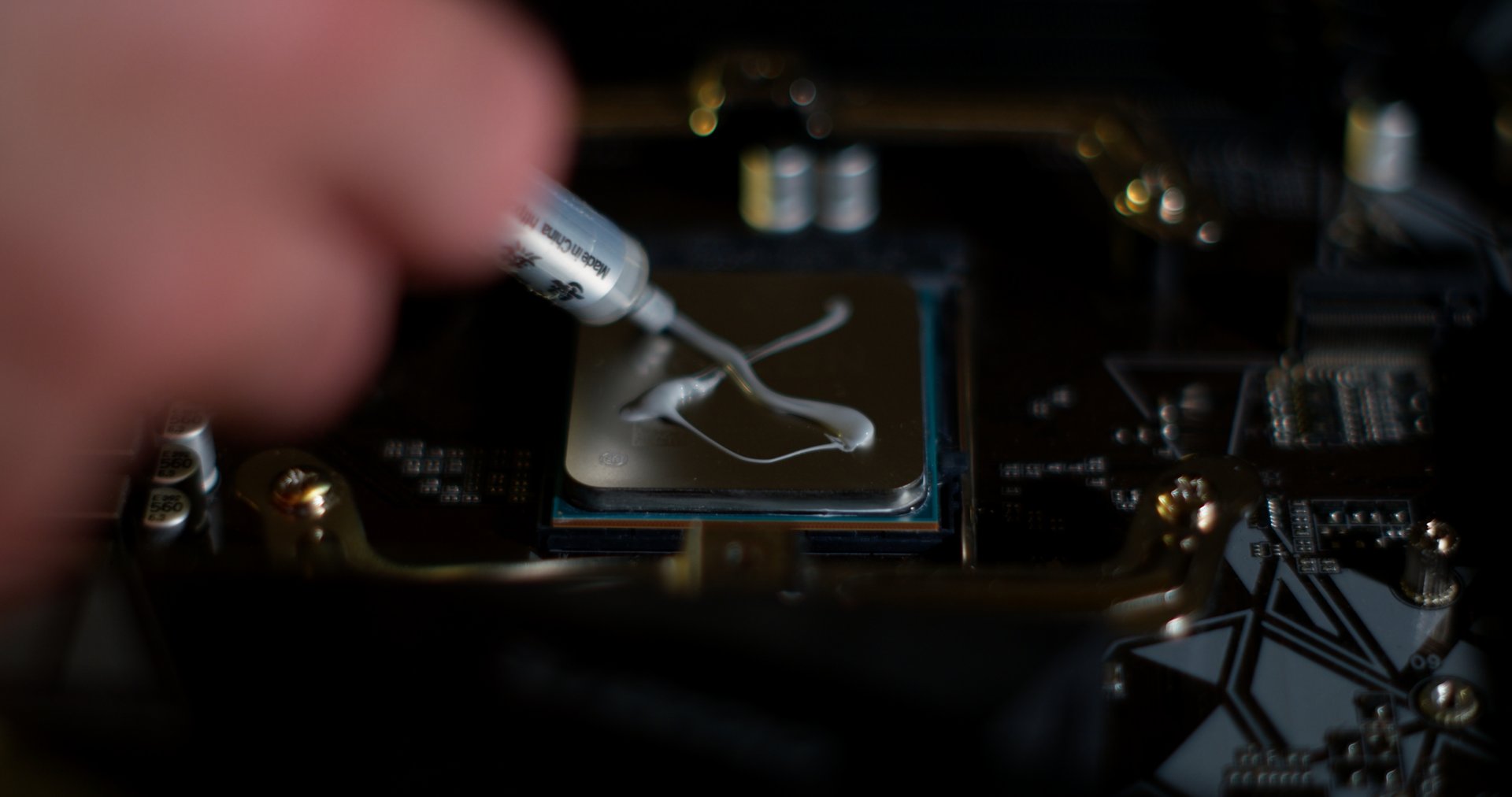 Close-up of thermal paste being applied to the surface of a computer processor. A crucial step in CPU installation and cooling, ensuring efficient heat transfer between the processor and the cooling system.