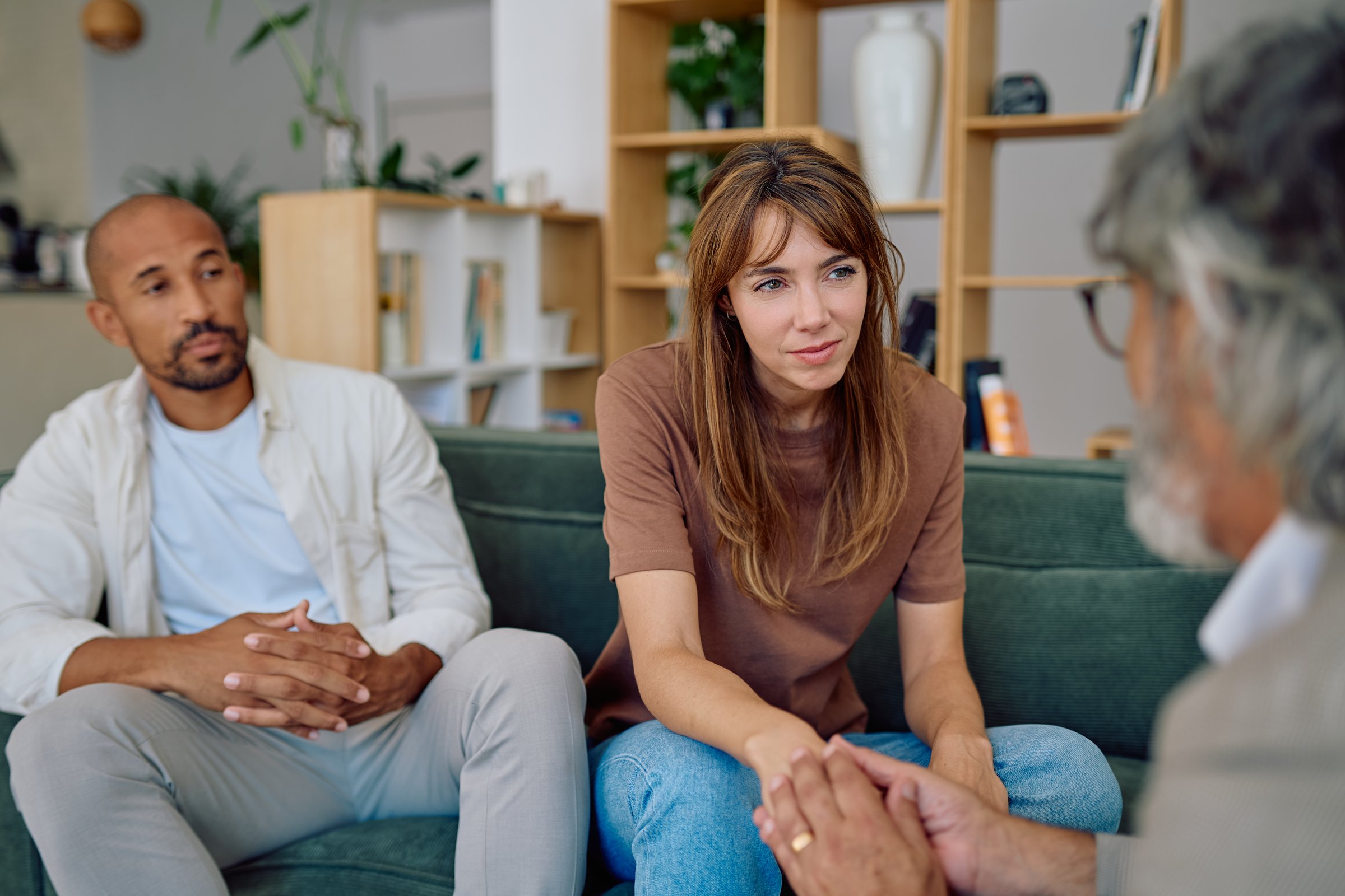 Young couple engaging in a therapy session, receiving professional support from a psychologist to navigate their relationship challenges
