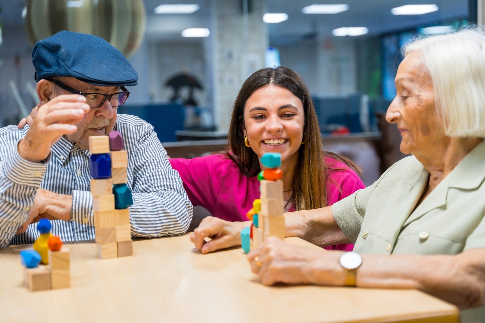 Nurse supervising two seniors playing skill development games in a nursing home