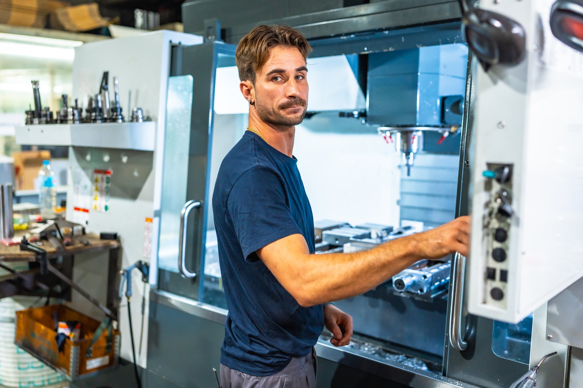 Industrial worker using mechanical machine to shape metal in fabrication factory