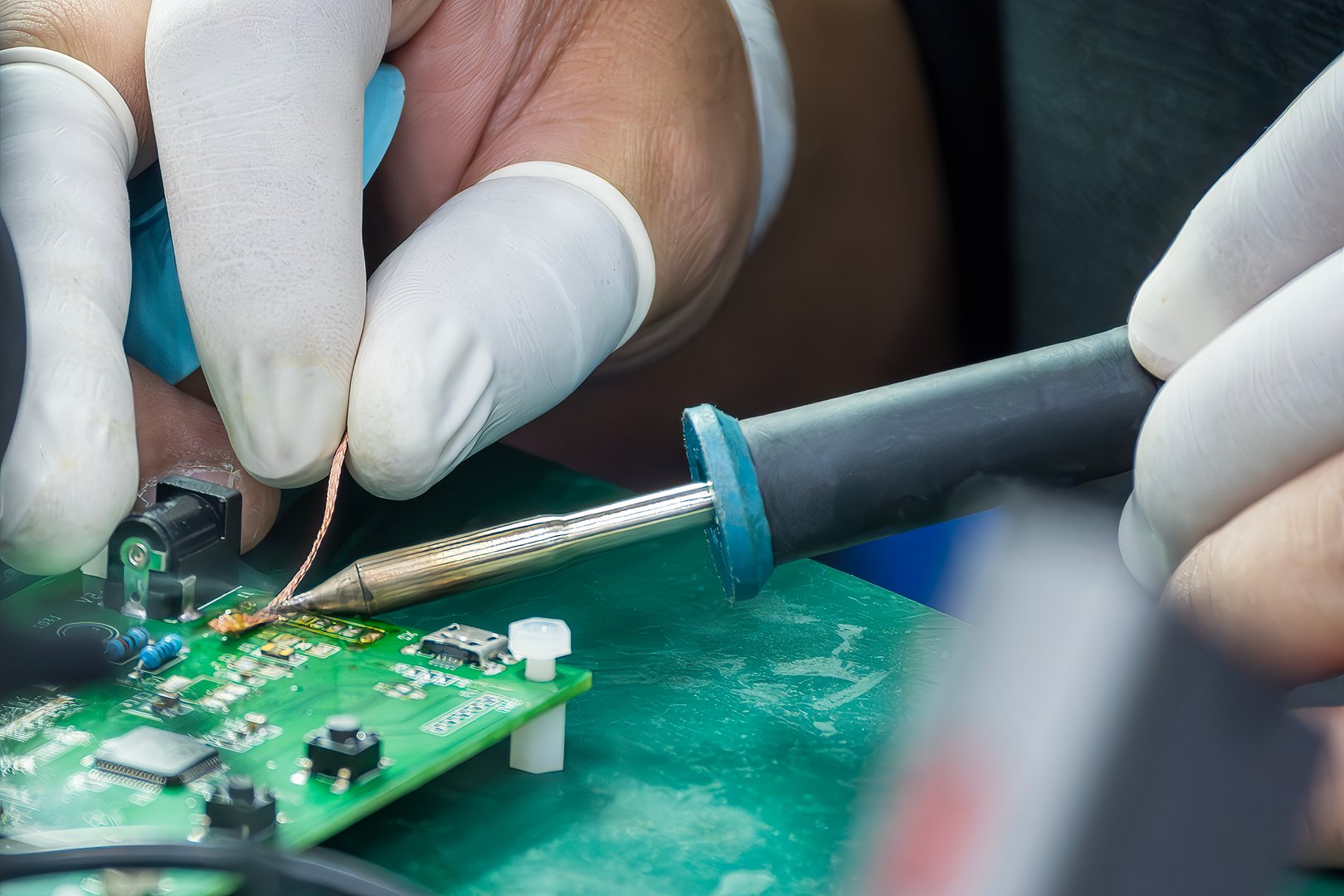 Close up scene the soldering operation by skill operator with rubber finger cot. The repair work circuit board by skill operator.