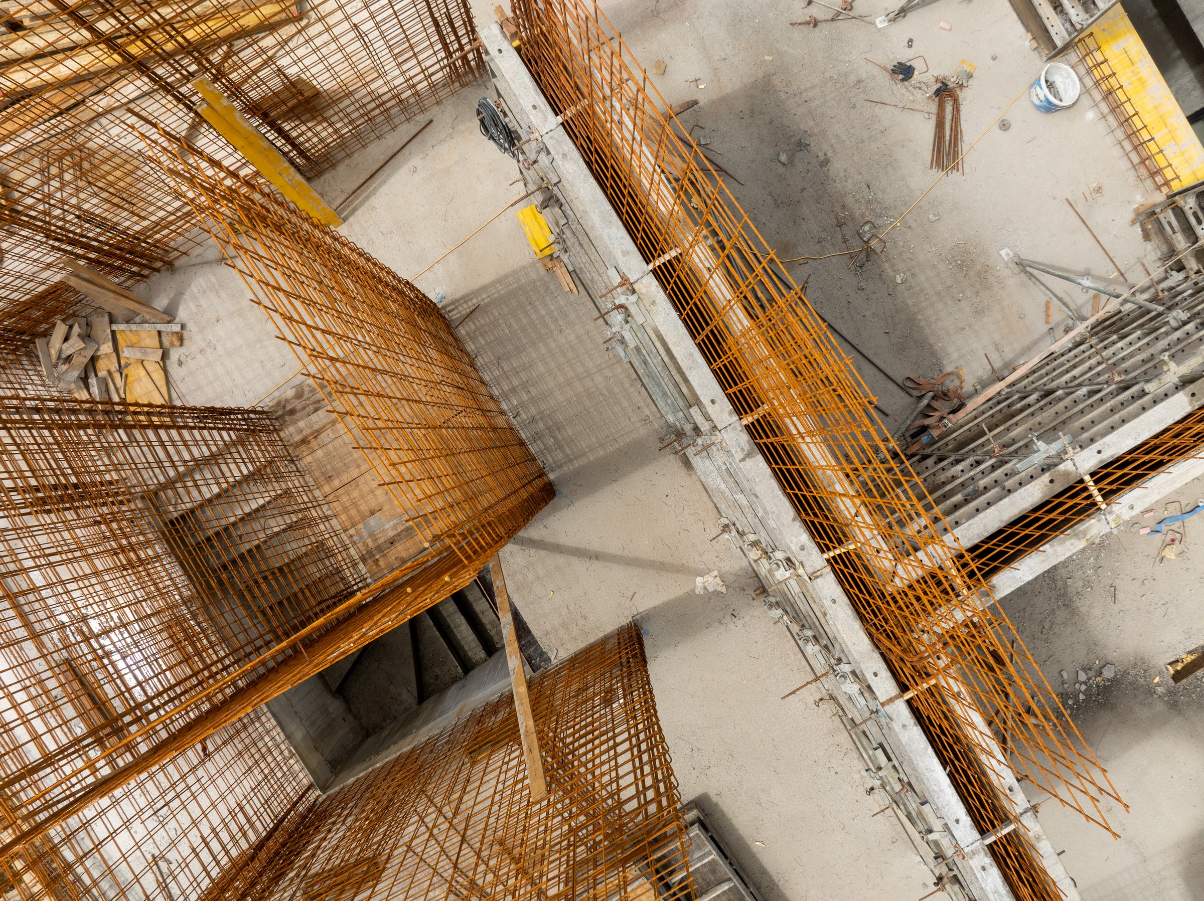 Aerial shot of a construction site interior featuring reinforcement bars and concrete framework. Ready for the next phase of concrete construction.