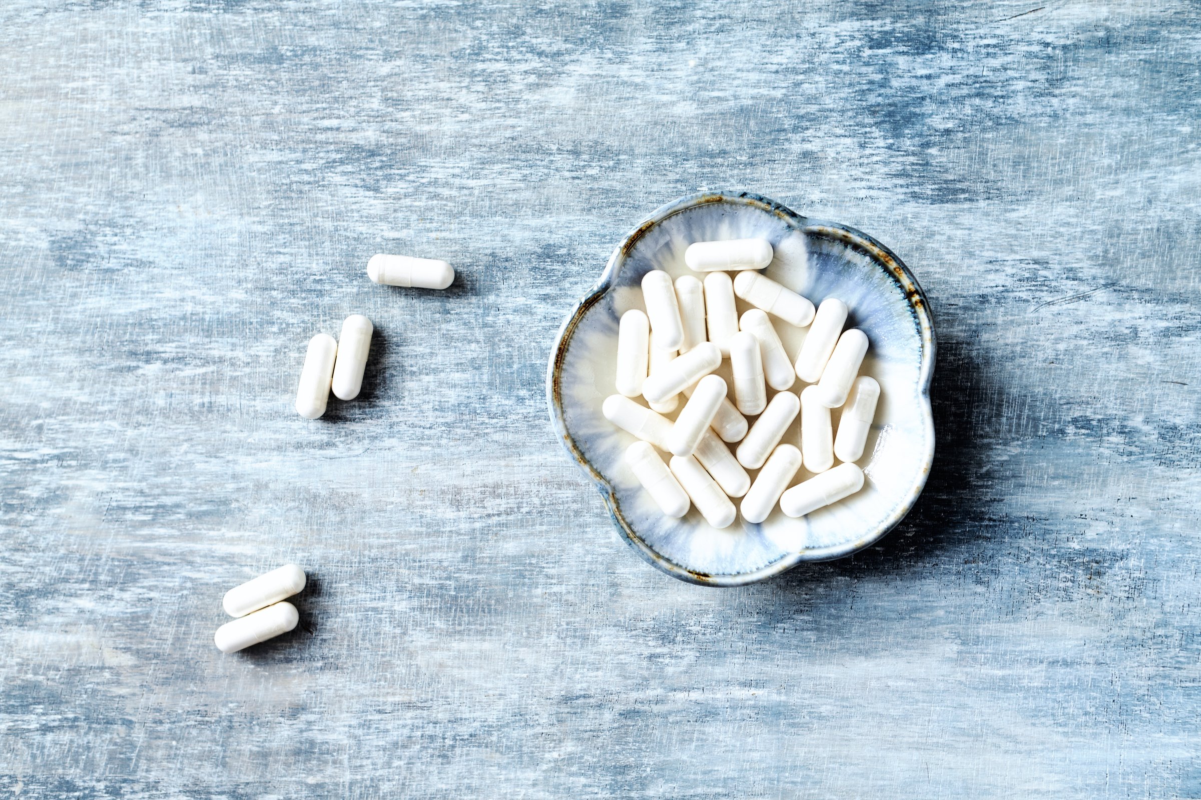 Theanine capsules. Concept for a healthy dietary supplementation. Rustic wooden background. Directly Above. Copy space.