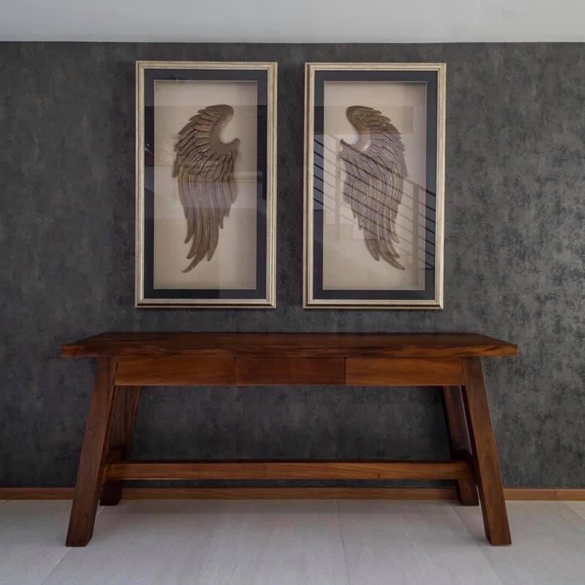 Mesa consola de líneas robustas en madera de parota con patas inclinadas tipo caballete y tres cajones centrales