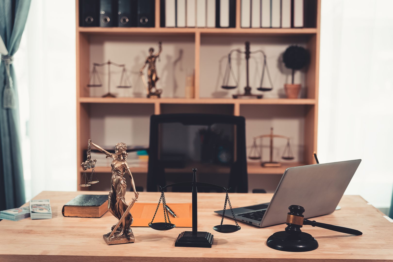 Realistic symbol showing golden scales on judge's table in courtroom background. Court gavel and scales of justice on table. Close up.