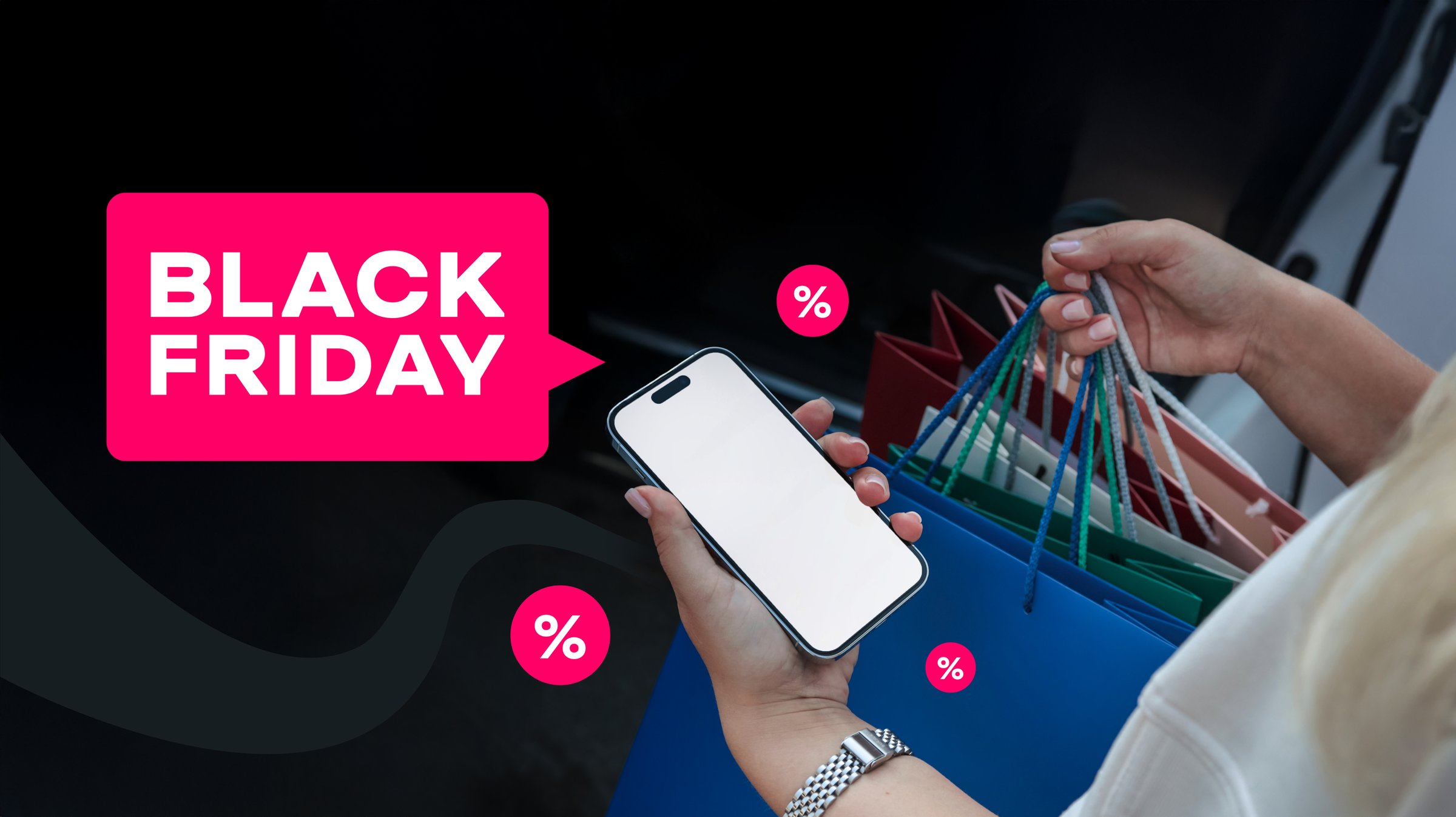 A person is holding a phone and shopping bags, ready for Black Friday deals