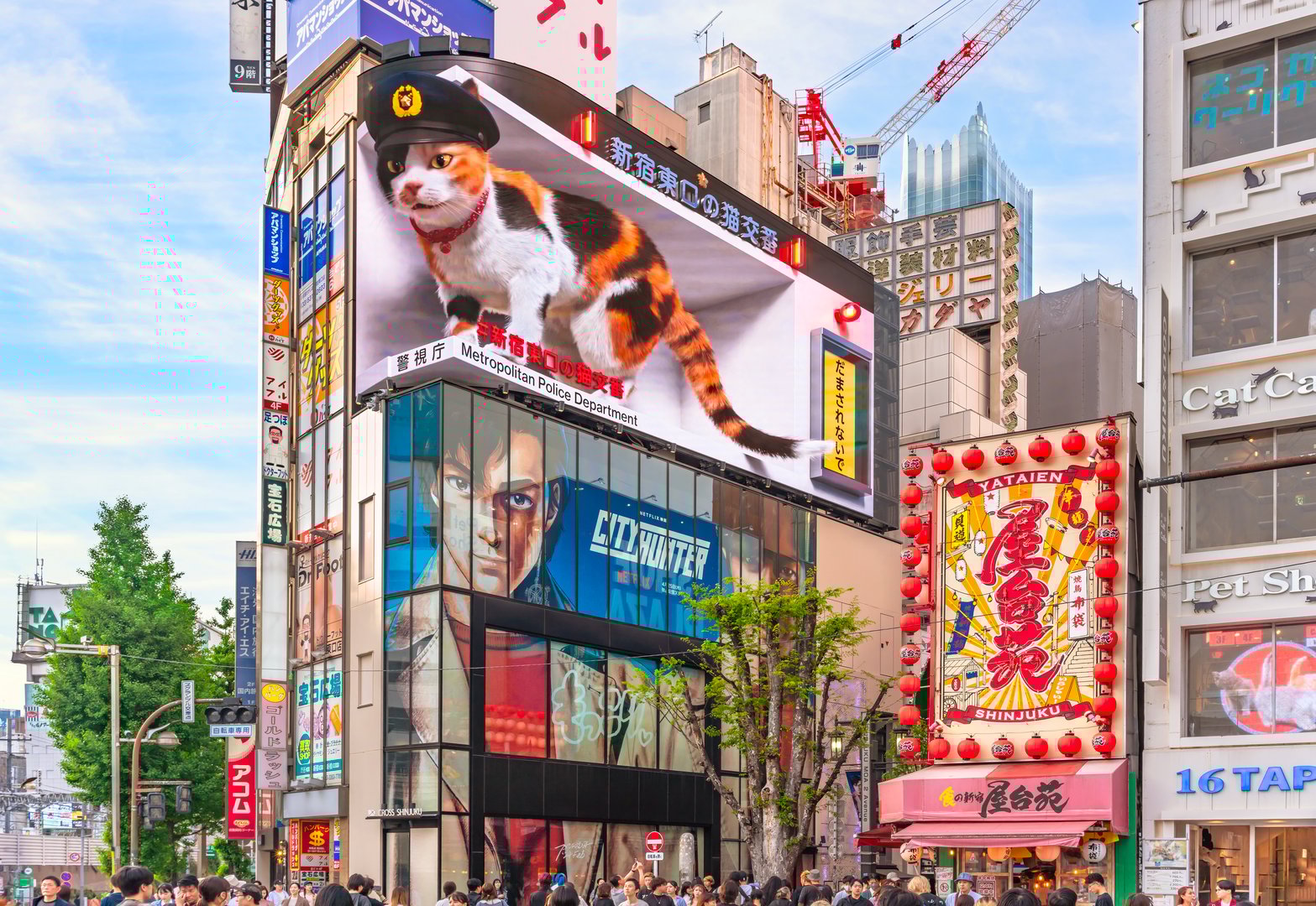 tokyo, japan - apr 28 2024: Netflix film poster of City Hunter or Nicky Larson below a curvy screen where a giant 3D calico cat wearing a kepi in a kban police station prevents Kabukicho scams.