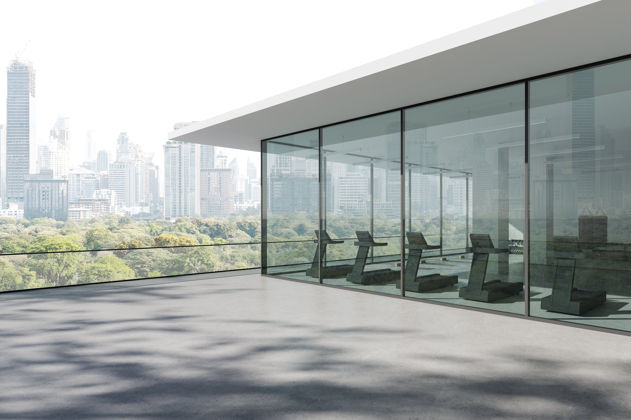 Treadmills inside a modern glass-walled gym with panoramic city view and lush green park, minimal architectural style, 3D Rendering
