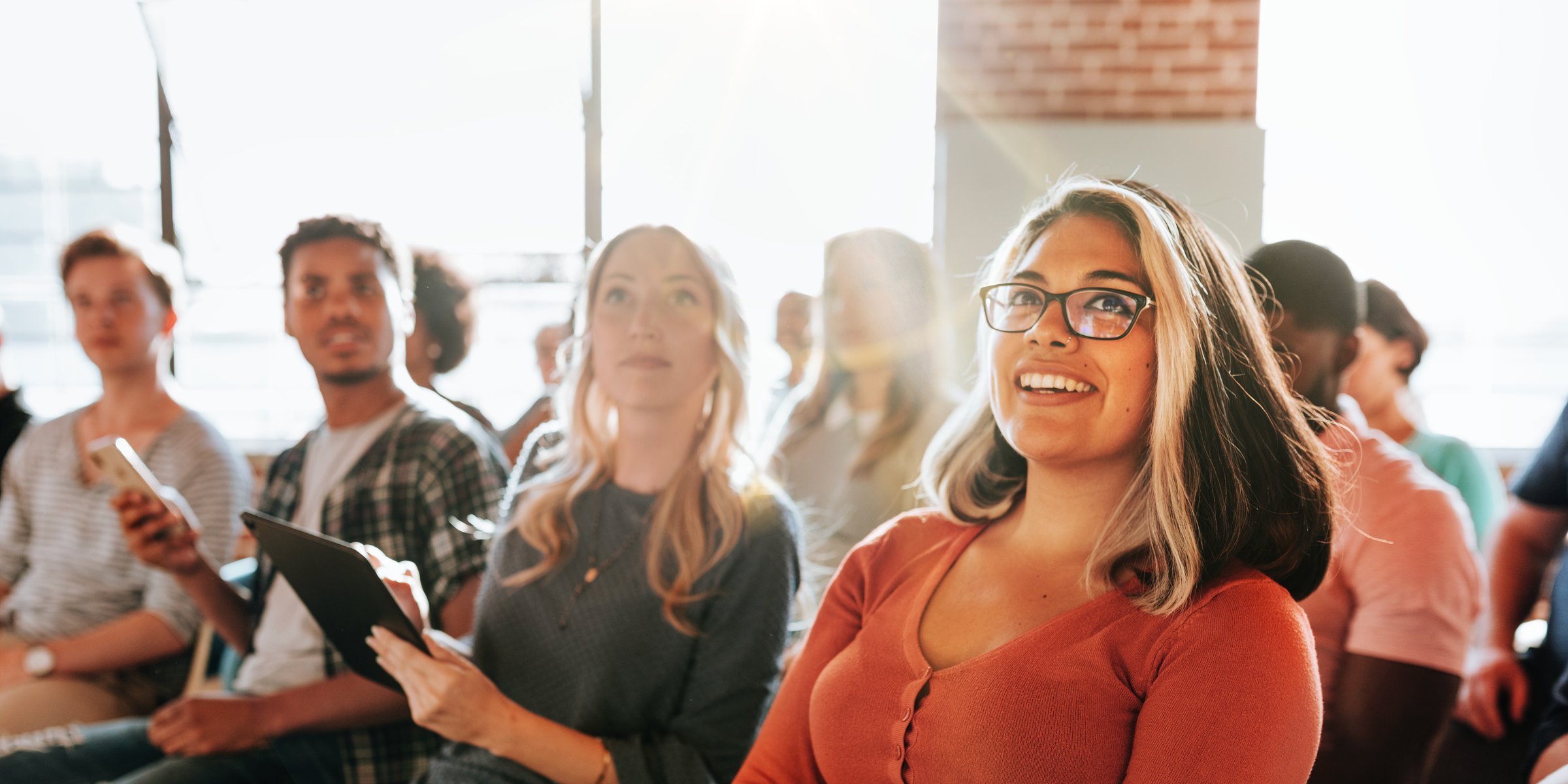 Businesswomen using sticky notes on glass wall