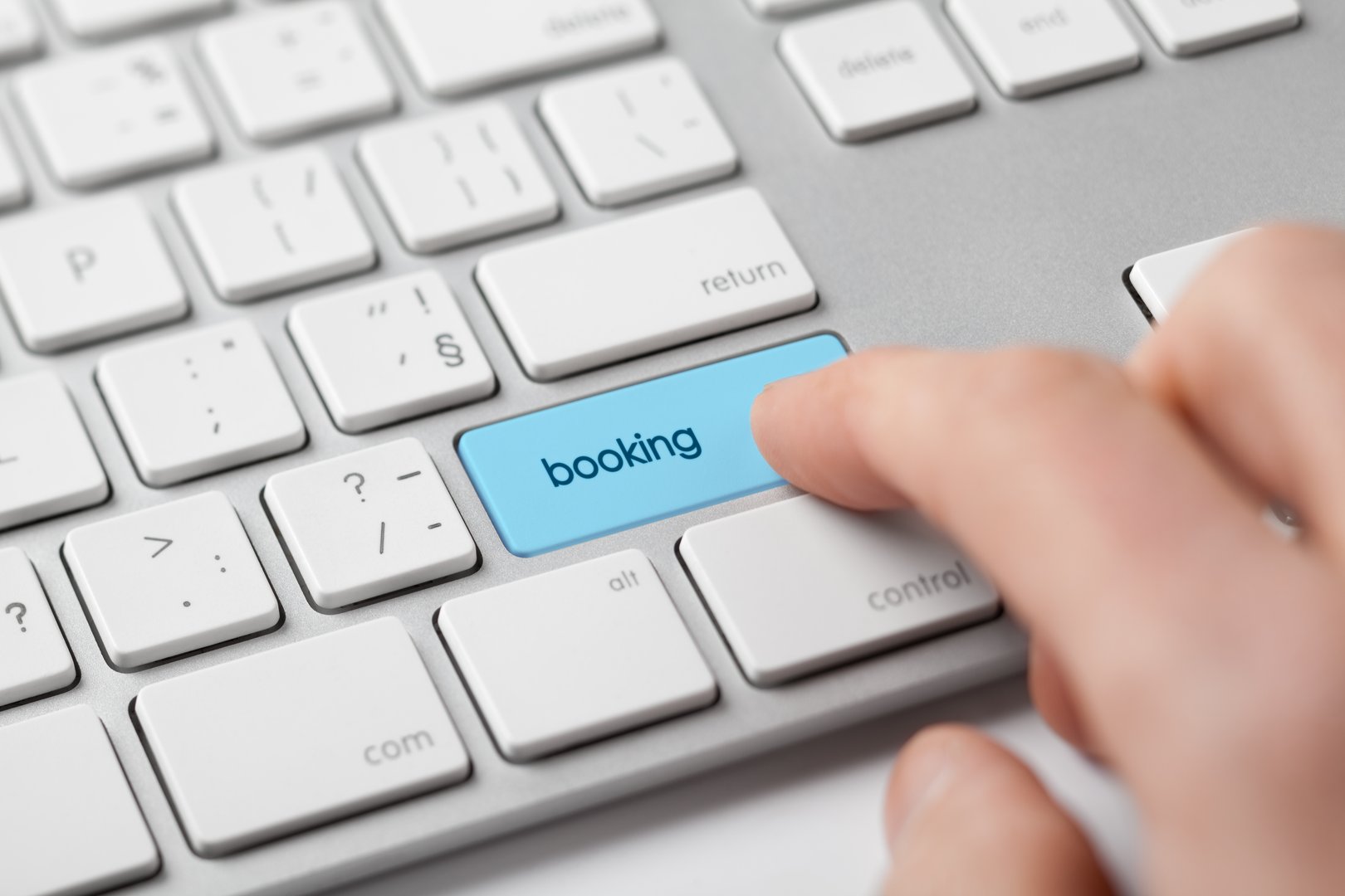 Online booking concept. Man click on booking button on keyboard.