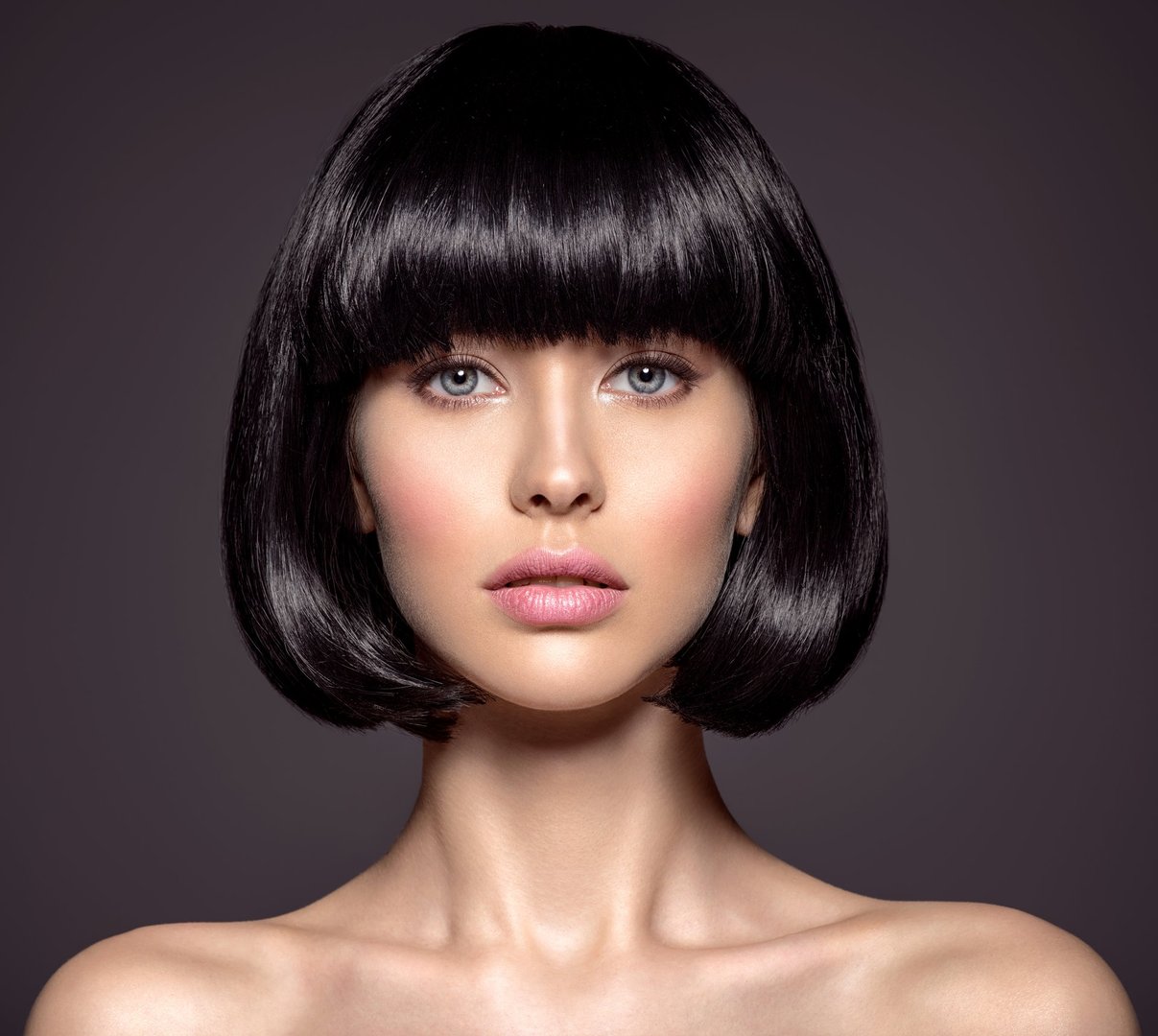 Woman with beauty short black hair - posing at studio. Fashion model with  straight hair. Fashion model at studio. Beautiful woman with a style  hairstyle. Closeup portrait of a fashion model.