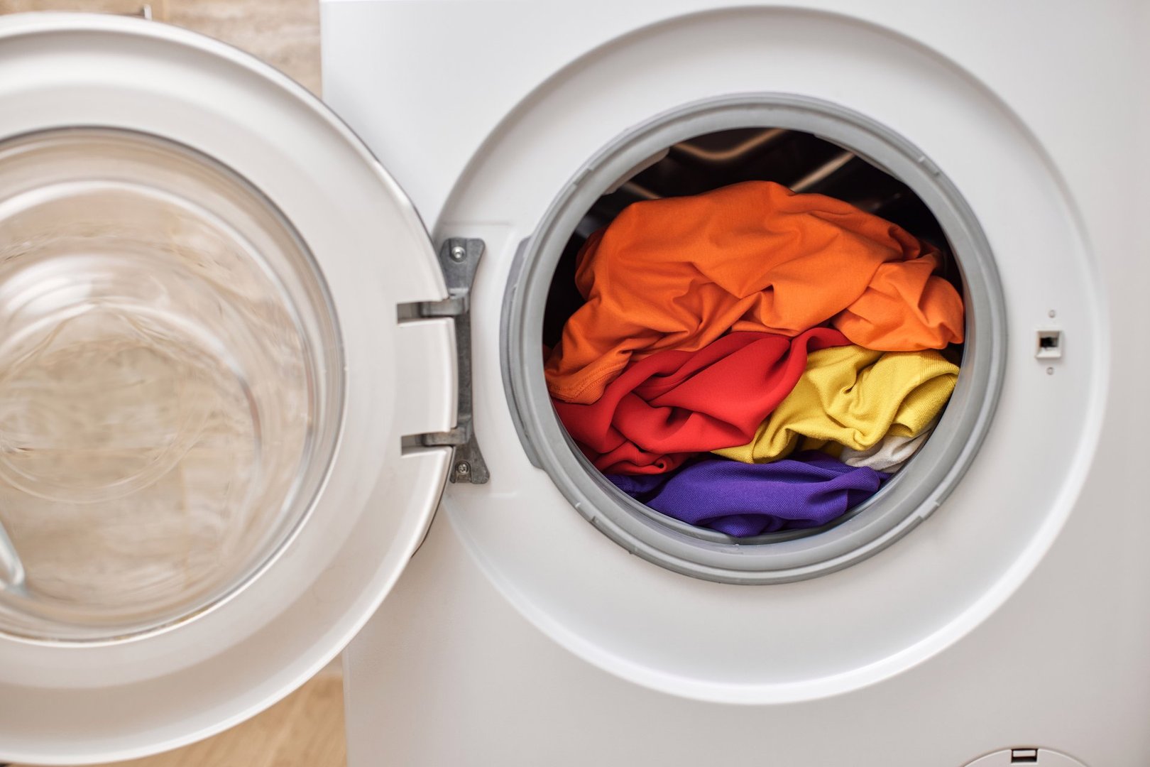 Colorful clothes inside washing machine with open door. laundry close up.