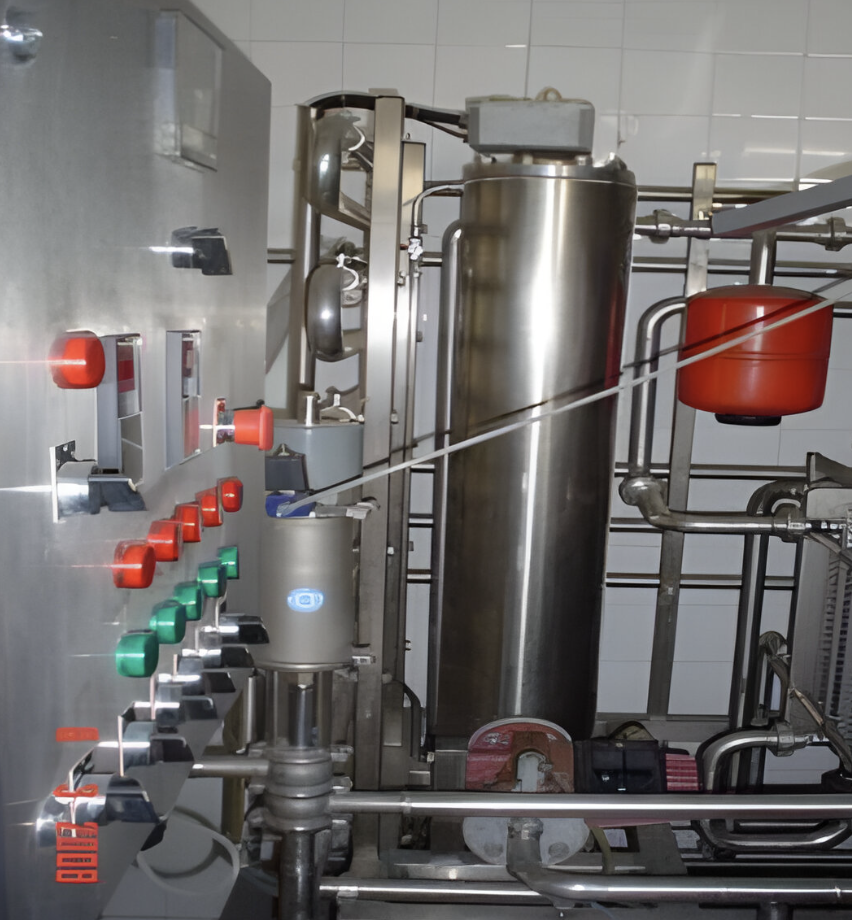 Industrial control panel with buttons and levers next to stainless steel tanks and pipes, suggesting a processing setup.