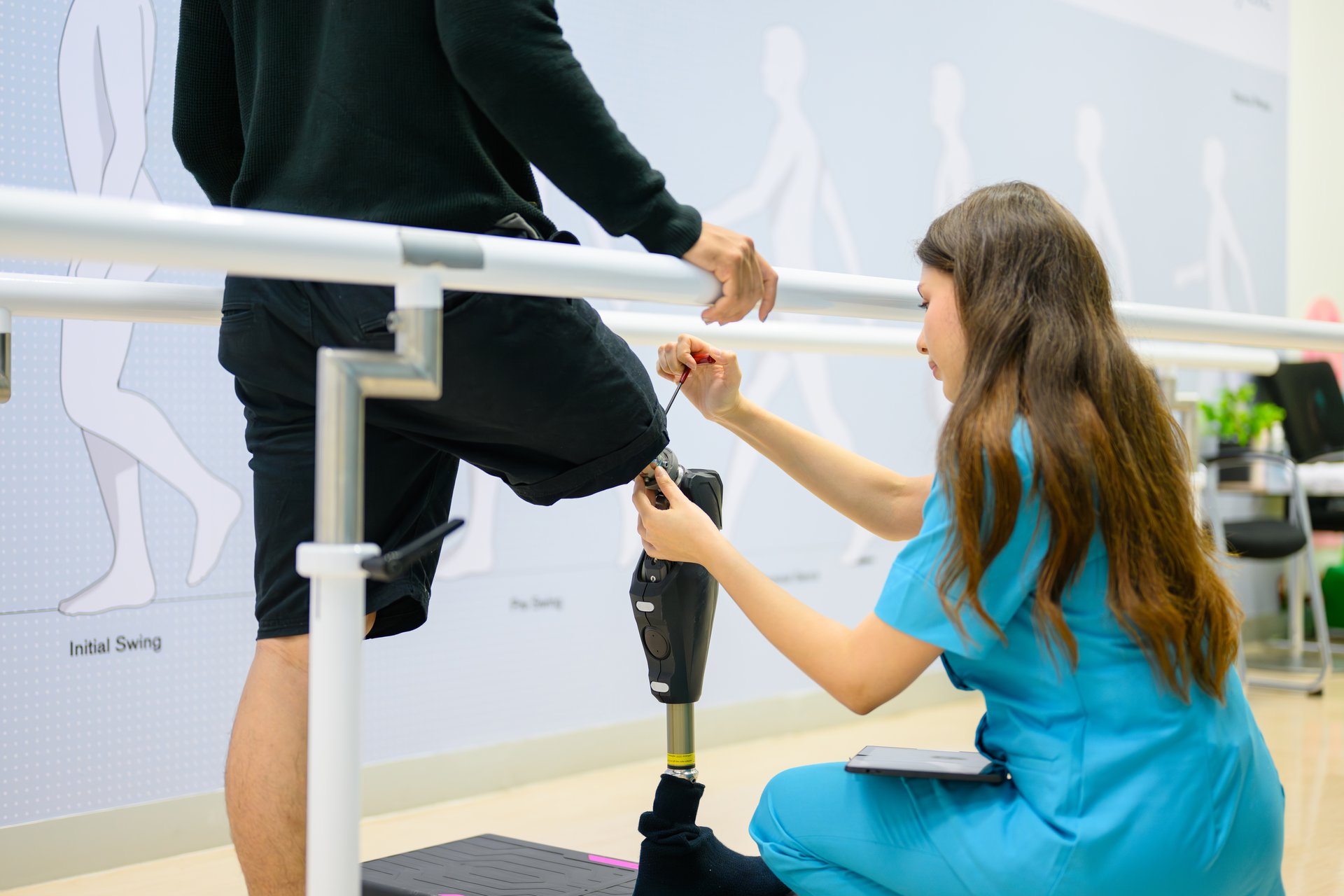 Physiotherapist adjusting prosthetic leg of patient in hospital, Disabled patient with treatment at health care center, New artificial limb production for disabled people