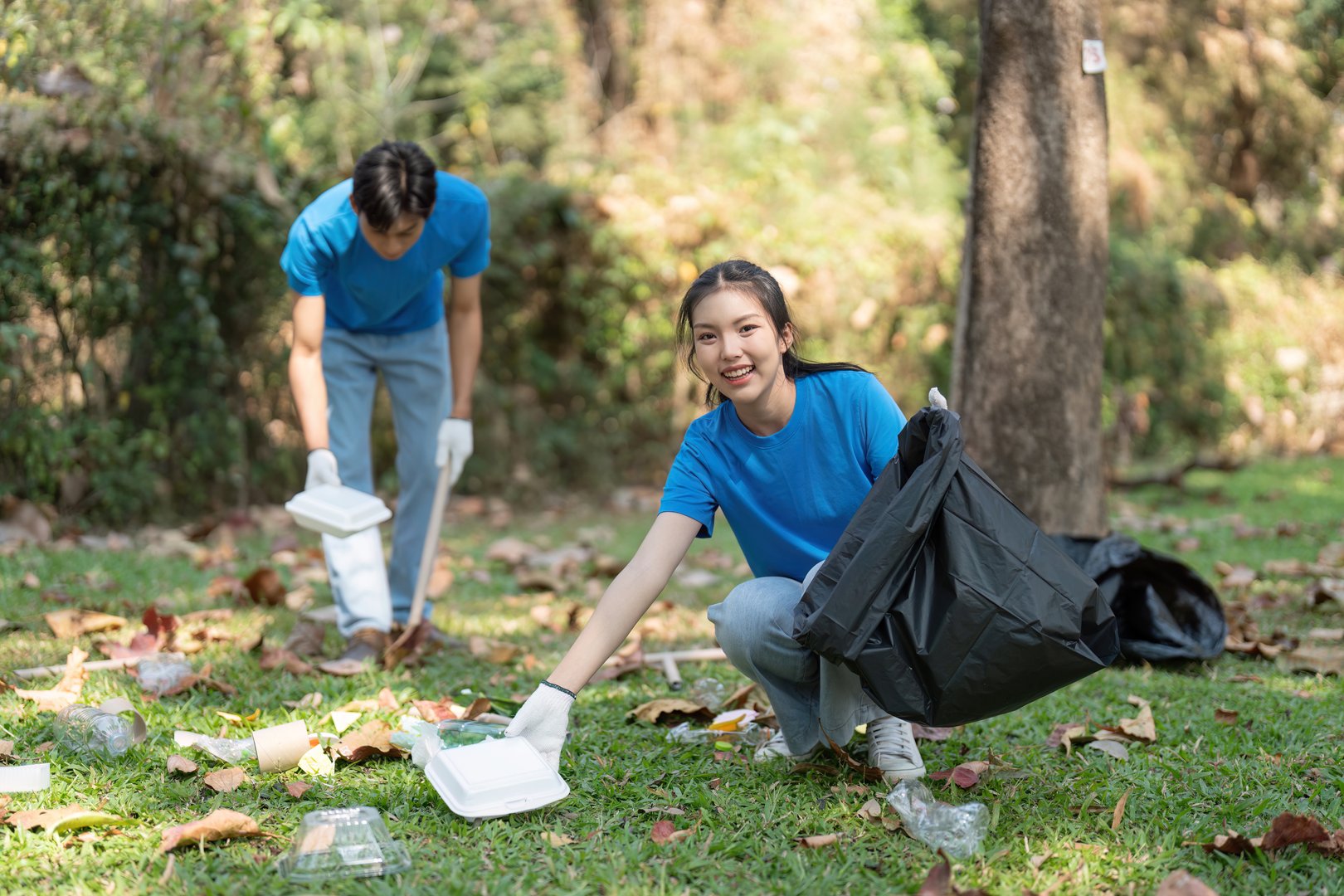 A group of dedicated volunteers actively participates in a park clean-up, demonstrating their commitment to maintaining a clean and green environment.