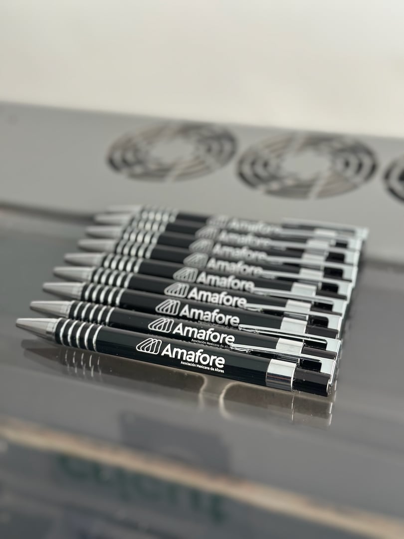 A row of black pens with "Amafore" logo neatly aligned on a reflective surface, showing branded stationery.