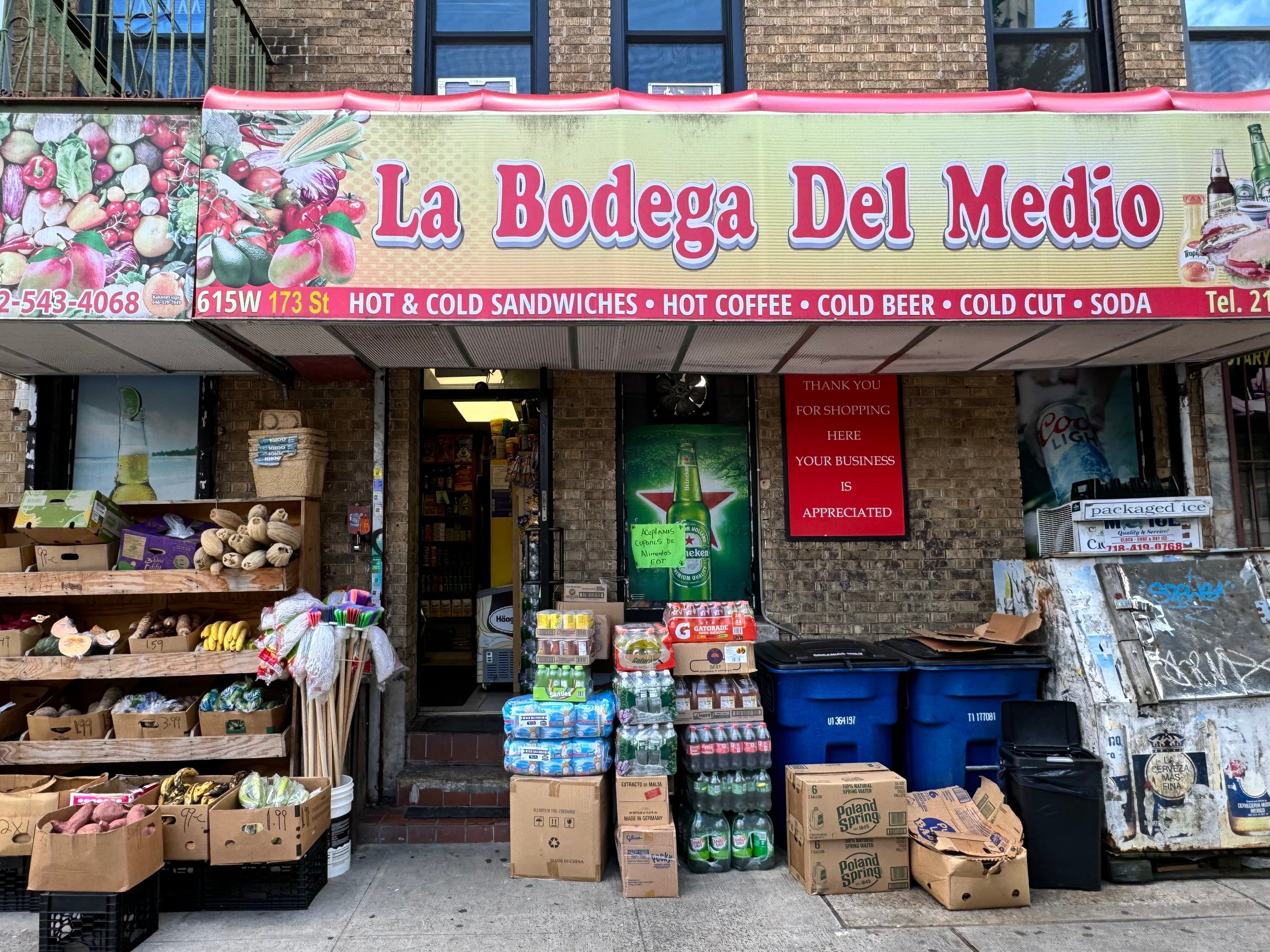 New York, NY USA - August 21, 2024 : "La Bodega del Medio" store sign over a deli with boxes of produce in front in Washington Heights, New York City in the summer