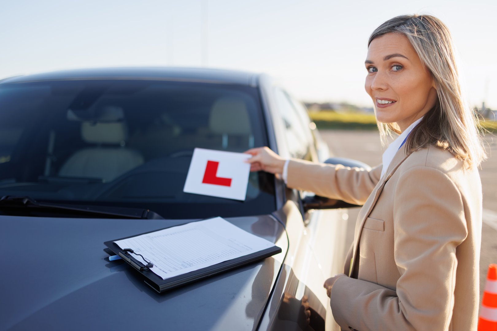 Instructor Preparing Car with Learner Sticker for Driving Lesson