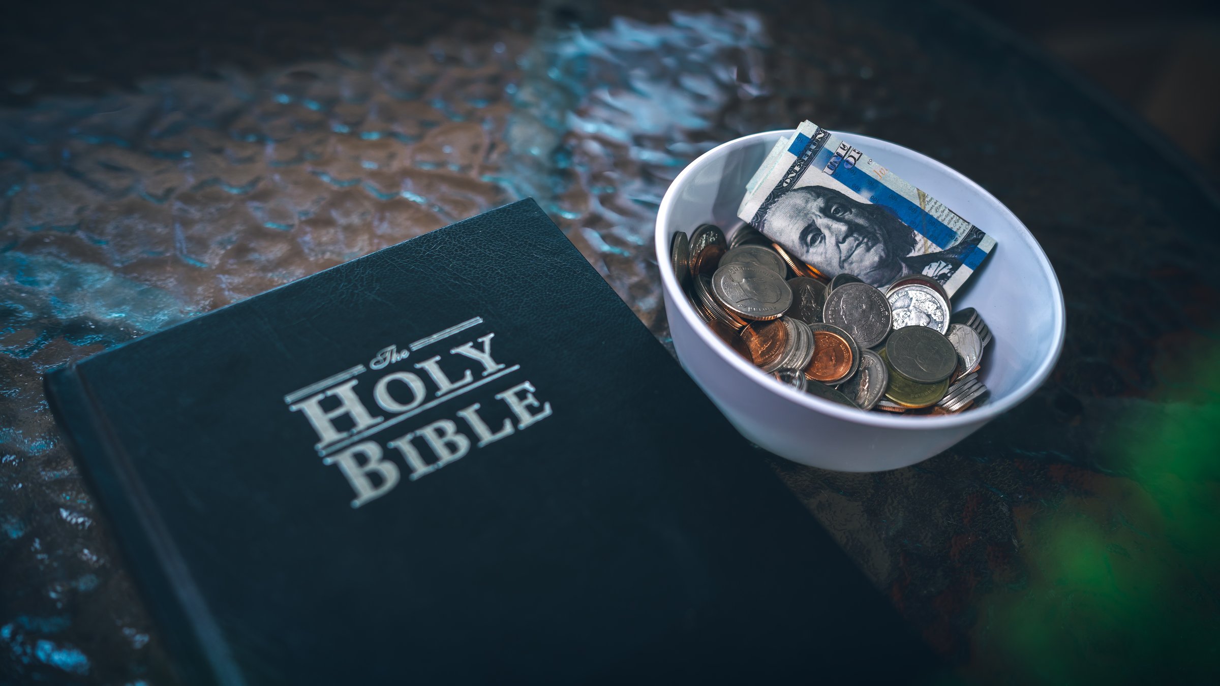 Coins with Holy Bible, a closeup, Christian biblical concept of tithing, Biblical concept of Christian offering