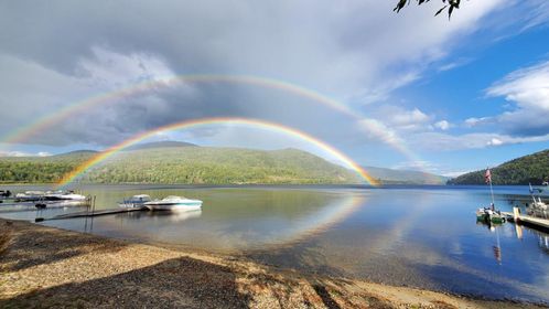 Northern lights fireworks over lake at Natanis Point