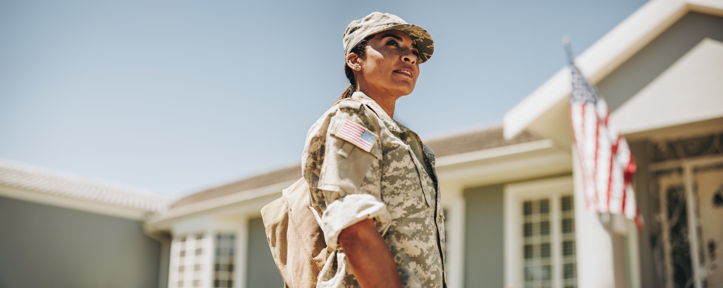 Female soldier standing outside home