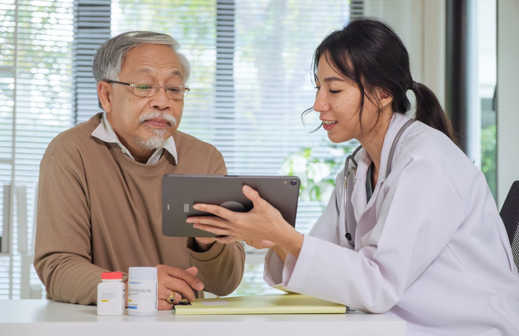 Senior patient consultation with doctor explaining symptoms and treatment during hospital appointment and health discussion