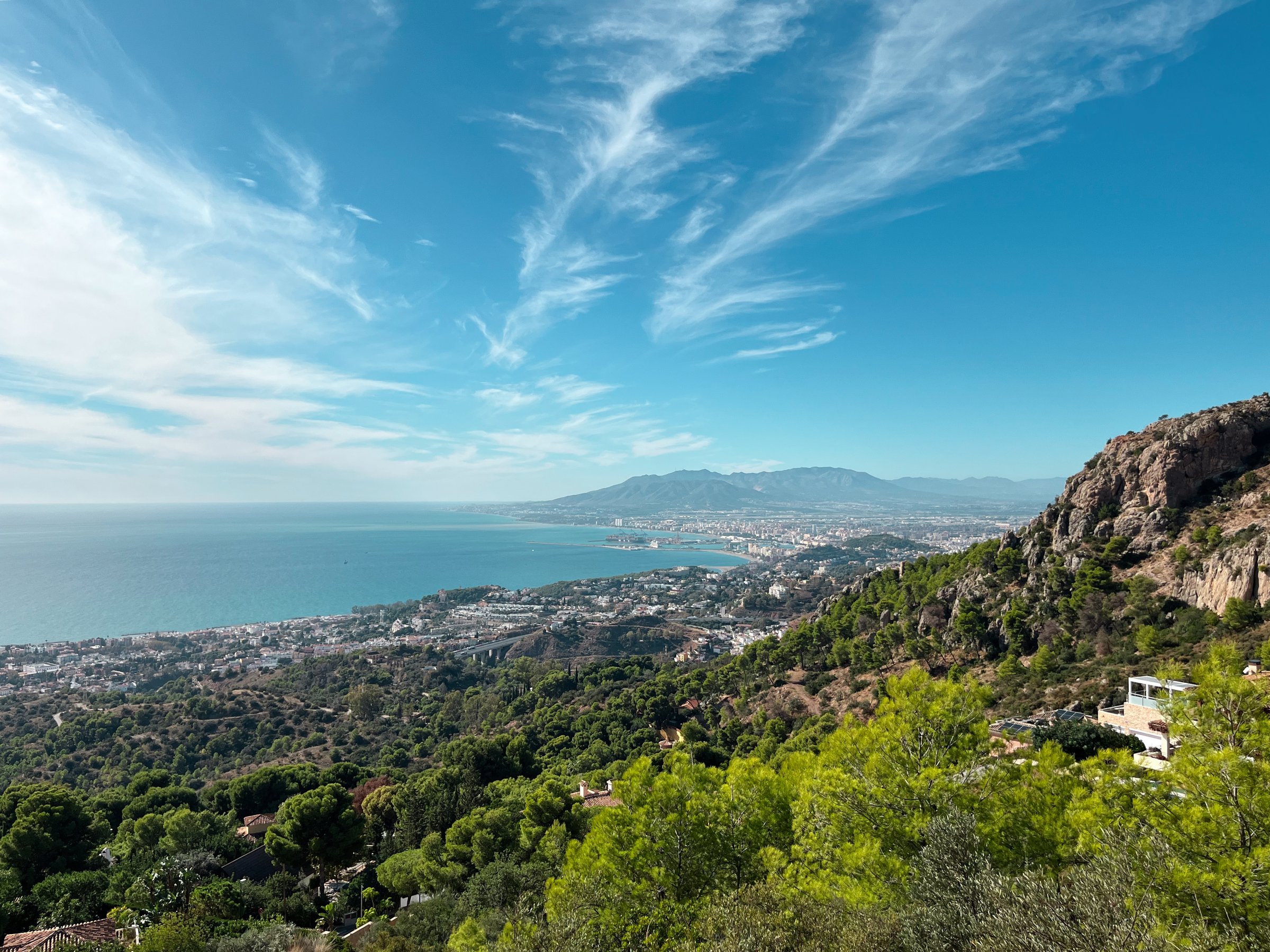 A sweeping panoramic shot captures the coastline near Malaga, Spain