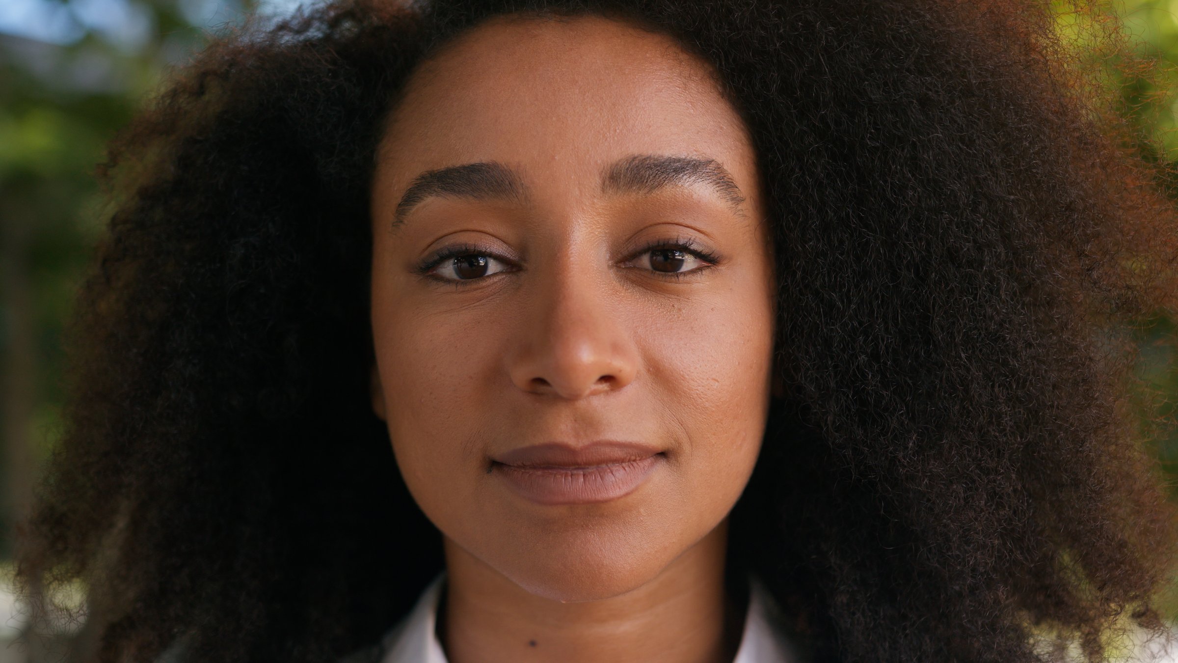 Close up young African American face woman businesswoman female looking at camera entrepreneur boss business work student lady confident girl ethnic expression portrait businessperson employee blink. High quality 4k footage