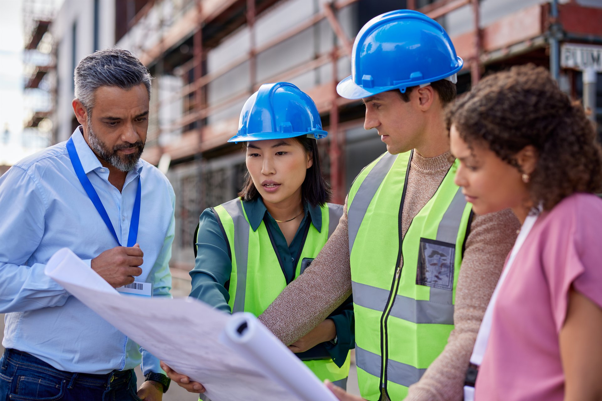 Construction team reviewing blueprints on job site