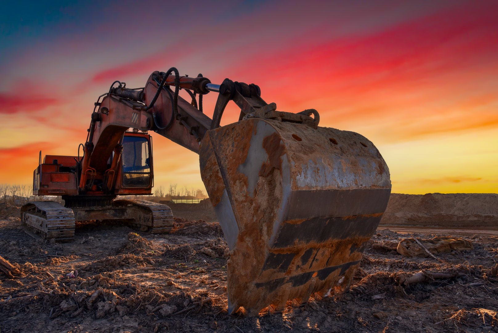 Excavator on sunset. Open-pit mining. Backhoe dig ground in quarry. Heavy construction equipment on excavation on construction site. Excavator on groundwork on dramatic twilight. Groundworks.