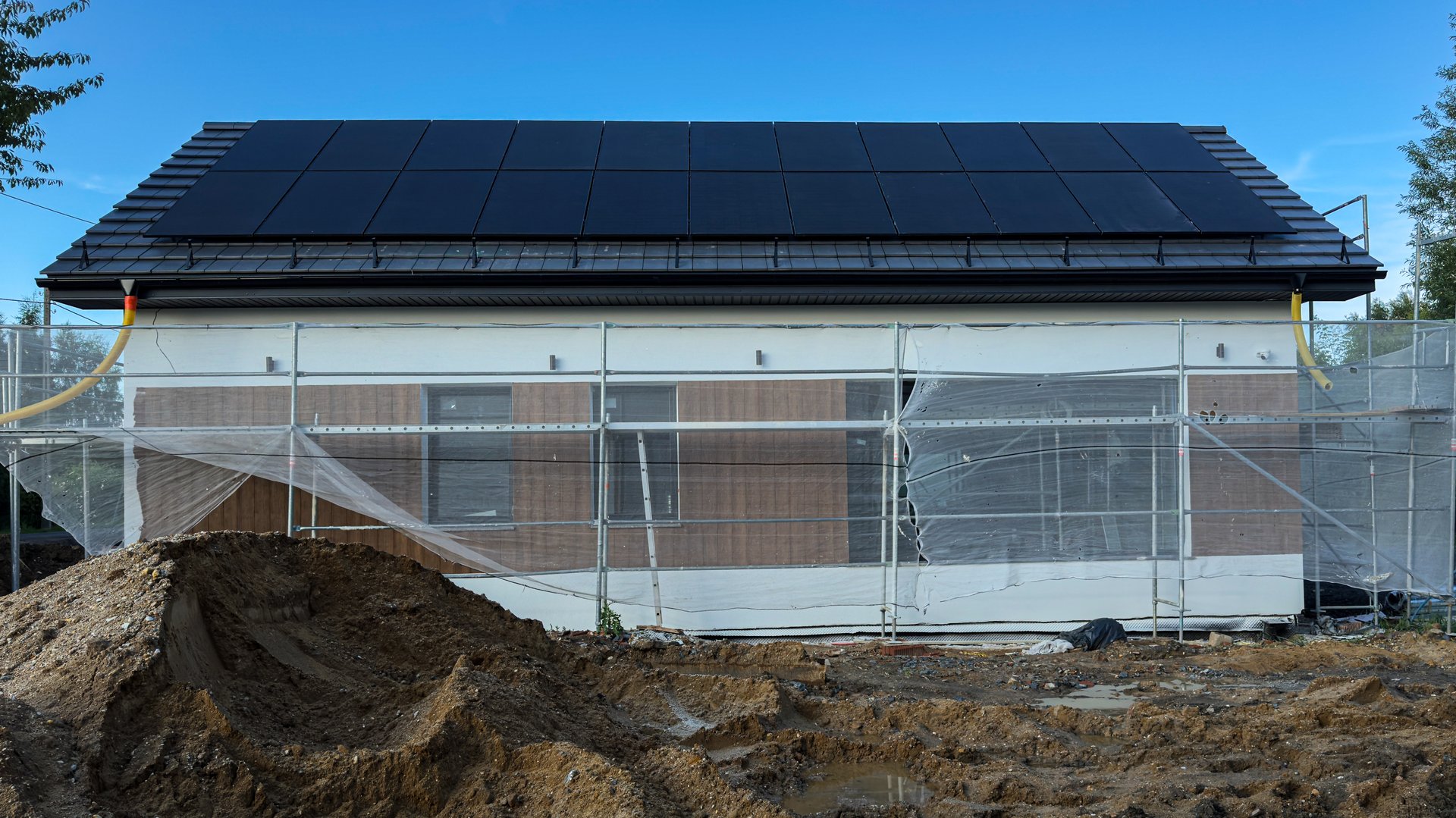 Newly built house with scaffolding and solar panels
