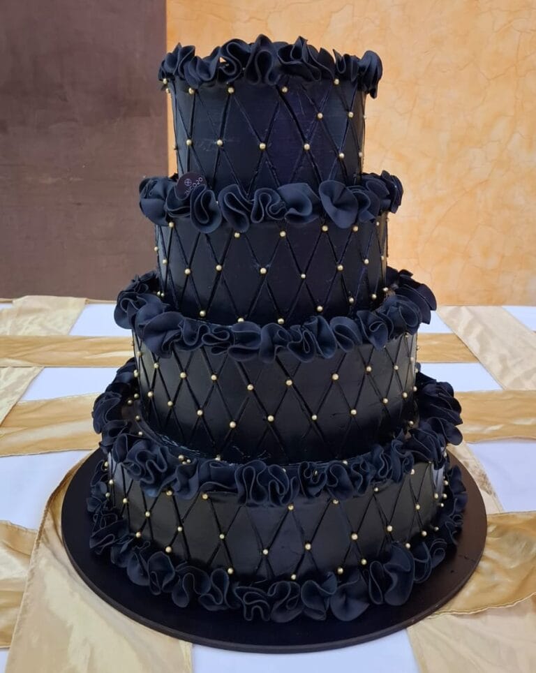 Elegante pastel negro con decoraciones doradas - Pastelería Cinco20