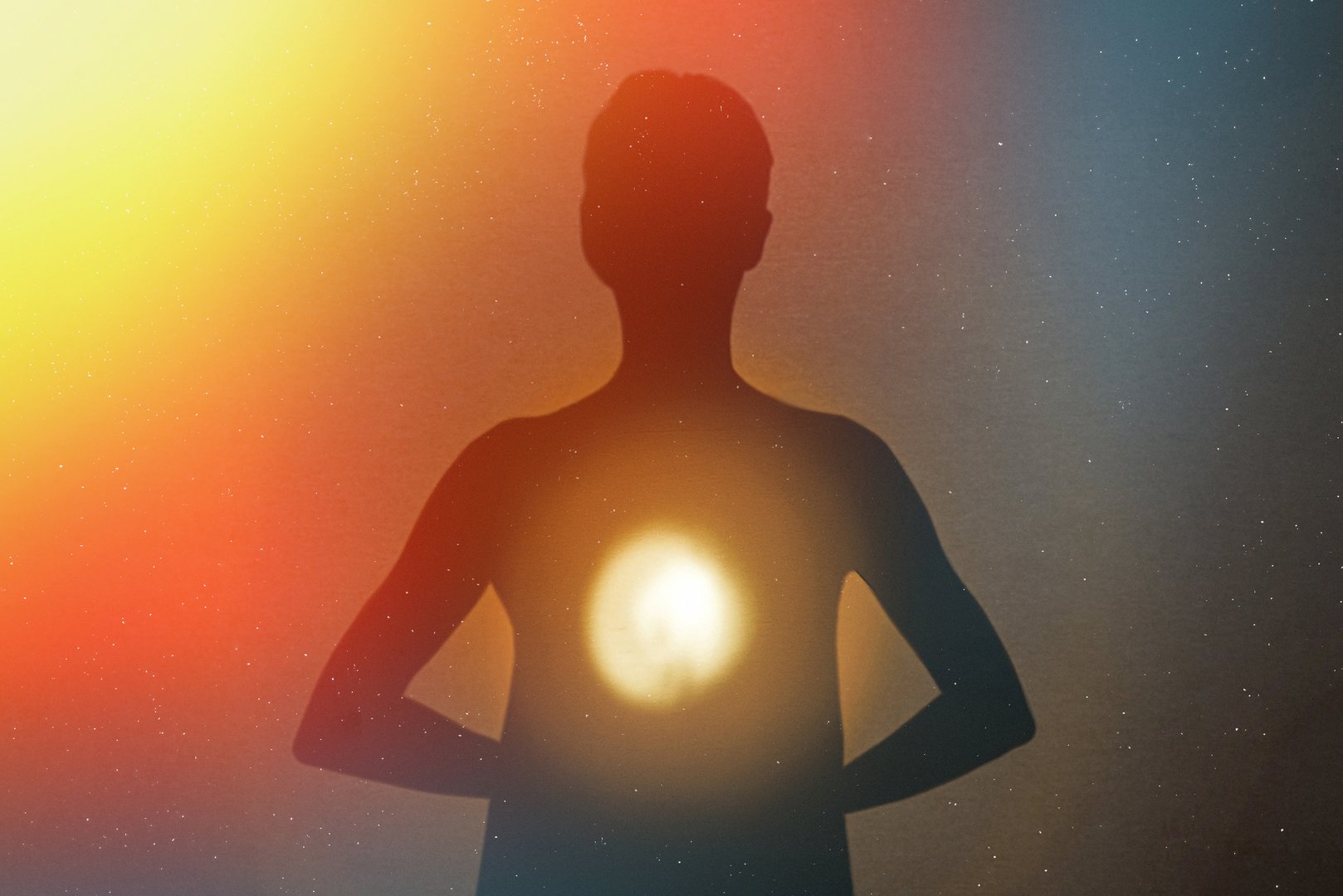 Human silhouette radiating light from within with energies and stars.