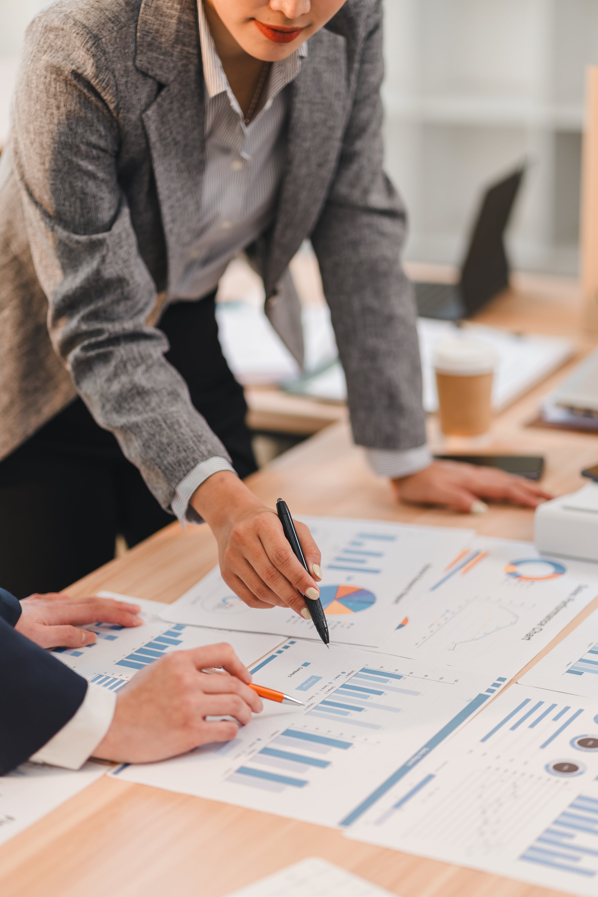 A Business professionals analyzing financial charts and graphs during meeting, discussing data trends and strategies in modern office environment