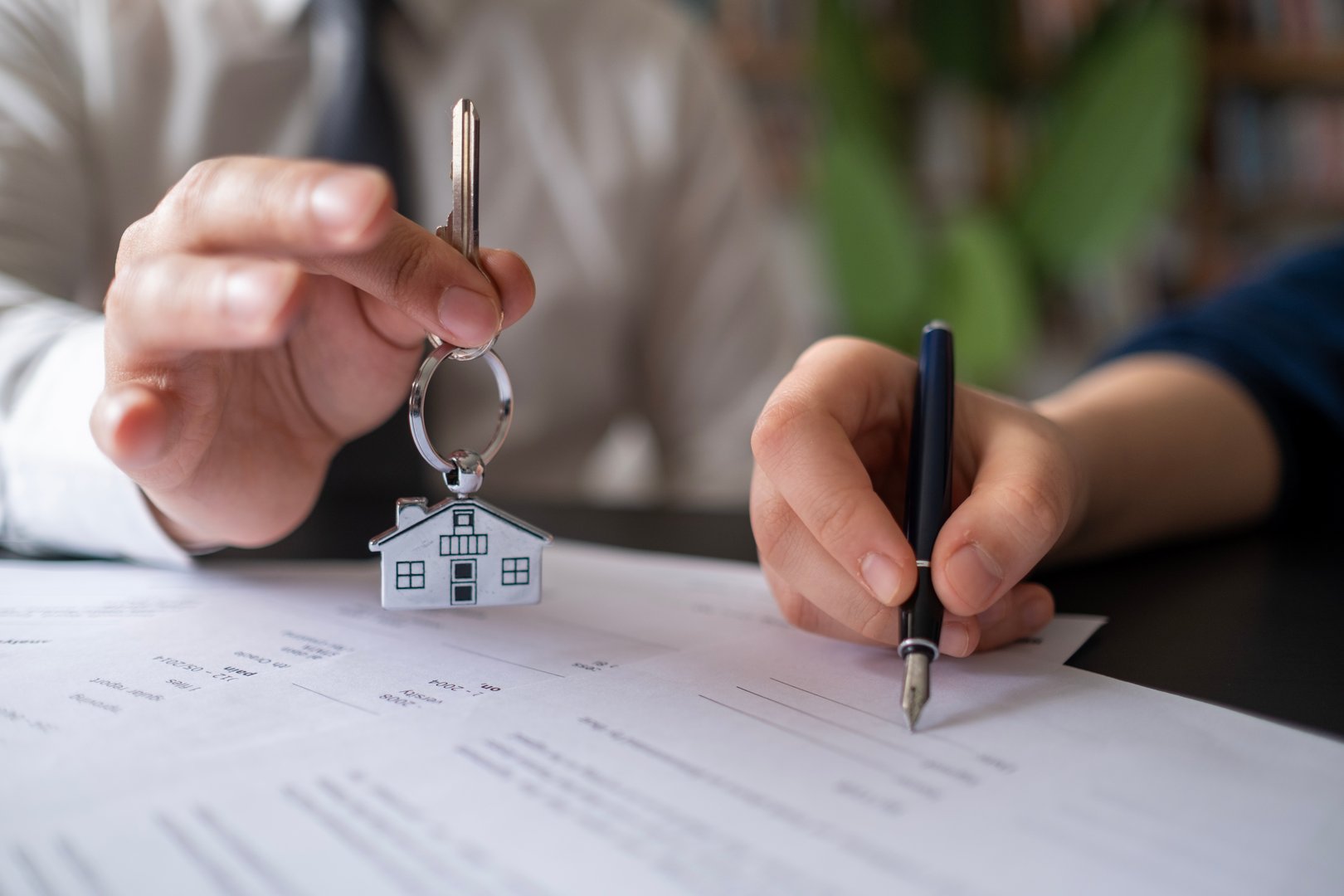 Real estate agent Sales manager holding filing keys to customer after signing rental lease contract of sale purchase agreement, concerning mortgage loan offer for and house insurance.