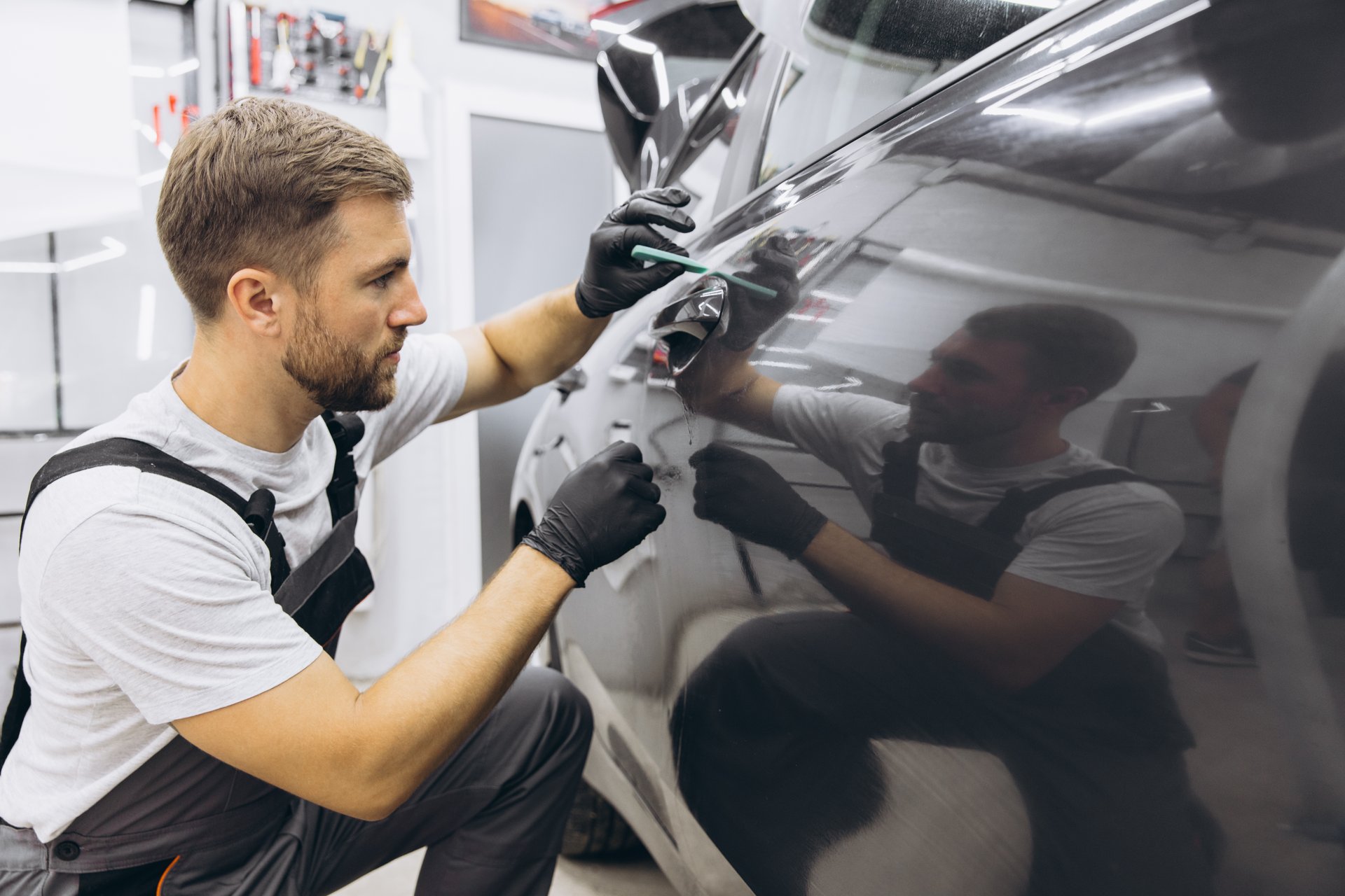 Close up to PPF installation process on a side car door. PPF is a Paint Protection Film which protect paint from scratches and stone chips. Concept of: Guard, Protect, Car, New, Work.
