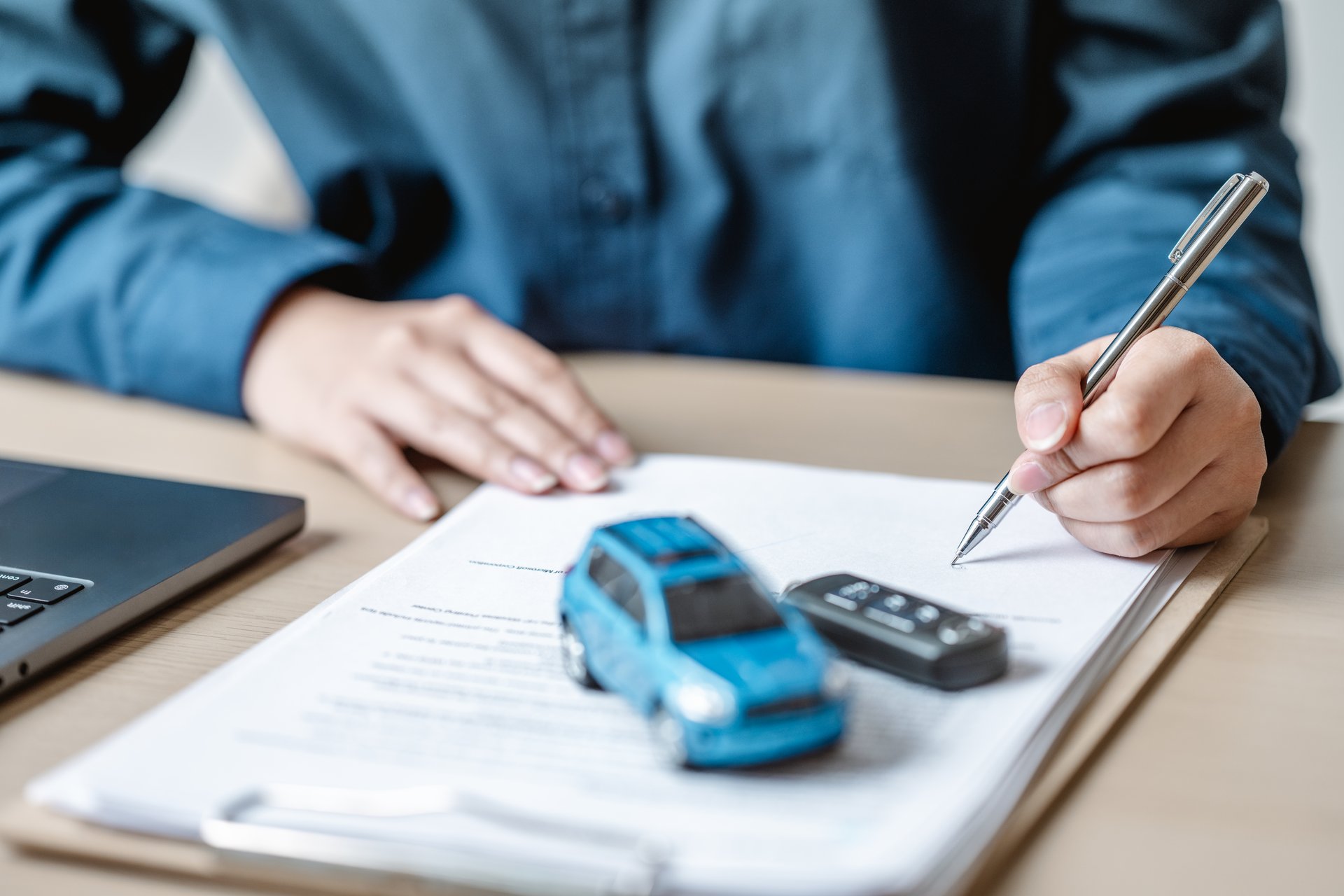Car insurance protect concept. Insurance agent. Insurance protection concept. A person is writing on a piece of paper with a pen. The paper has a car on it.
