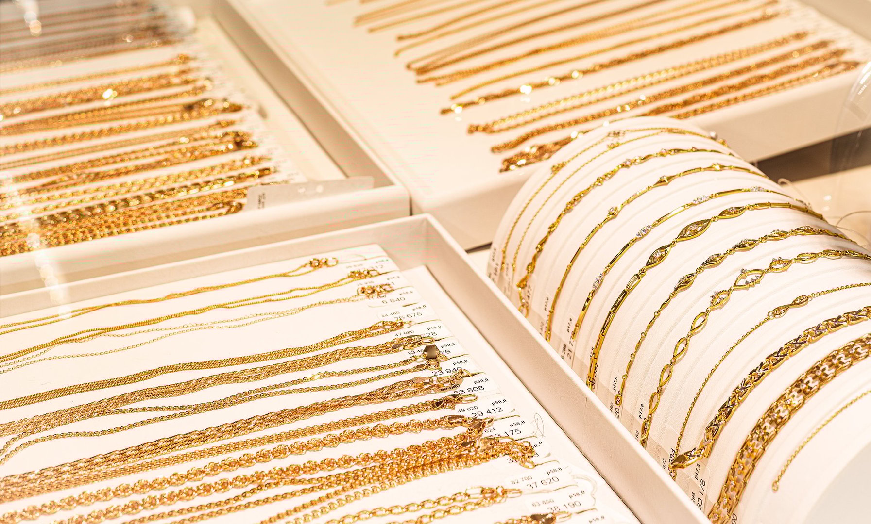 Assorted gold chains and bracelets on a jewelry display