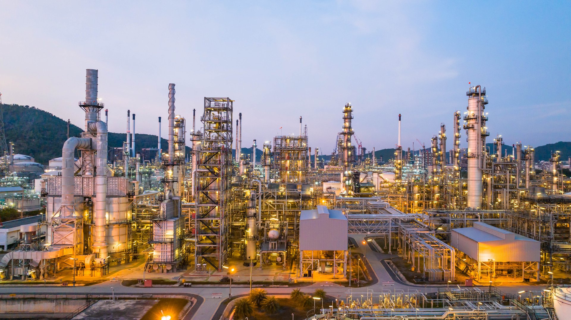 Oil and gas industrial refinery at twilight, Oil refinery and Petrochemical plant pipeline steel, Refinery factory oil storage tank and pipeline steel at night.